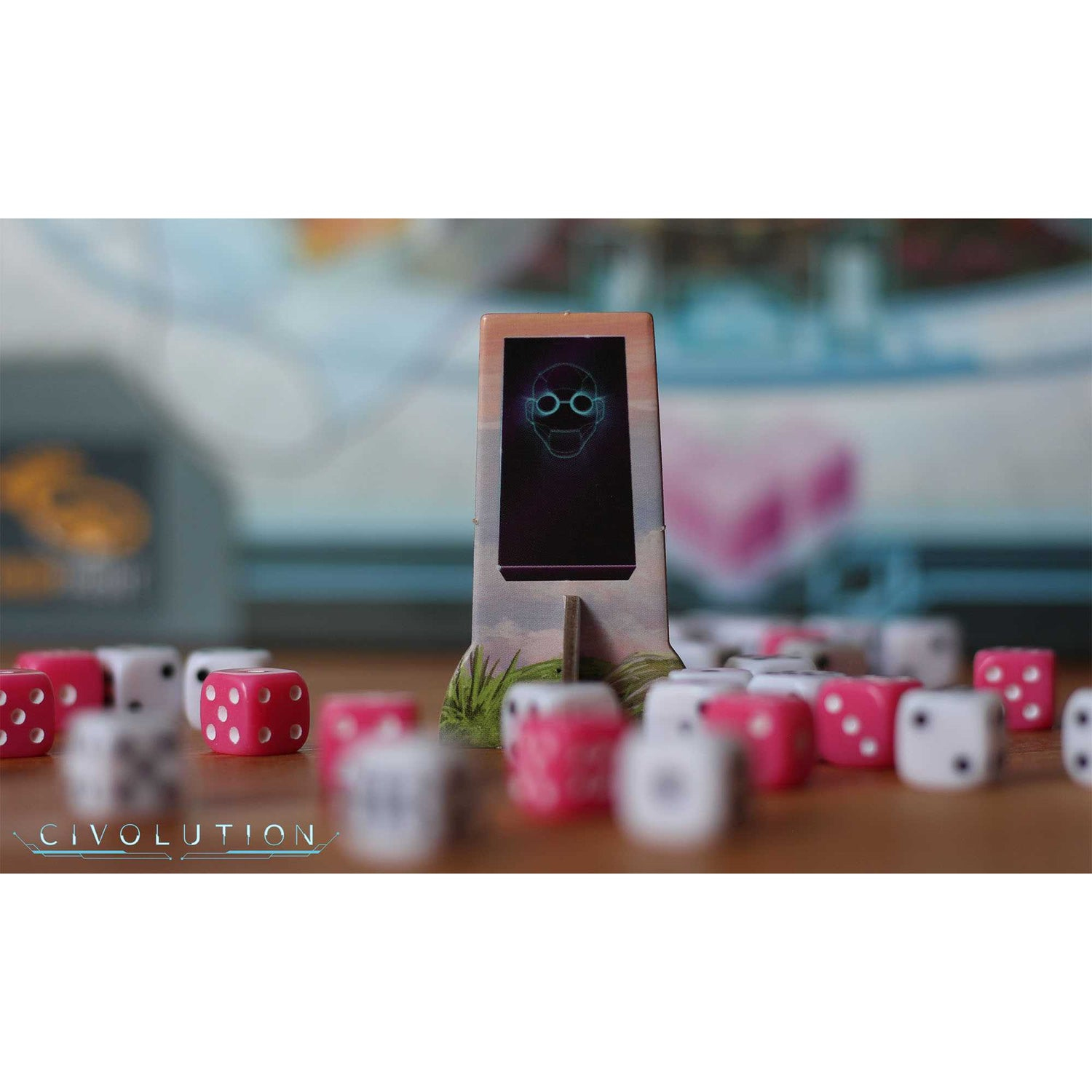 Ein Spielaufbau mit Würfeln, einem Bildschirm mit einem Gesicht und dem Civolution-Logo. Die Würfel sind rosa und weiß.