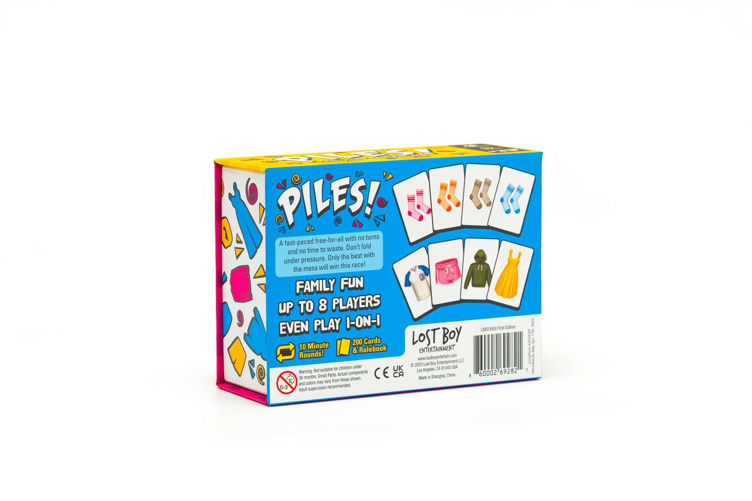 Eine Spielbox mit dem Titel 'PILES!' zeigt Karten- und Kleidungsillustrationen und wirbt für Familienspaß für bis zu 8 Spieler.