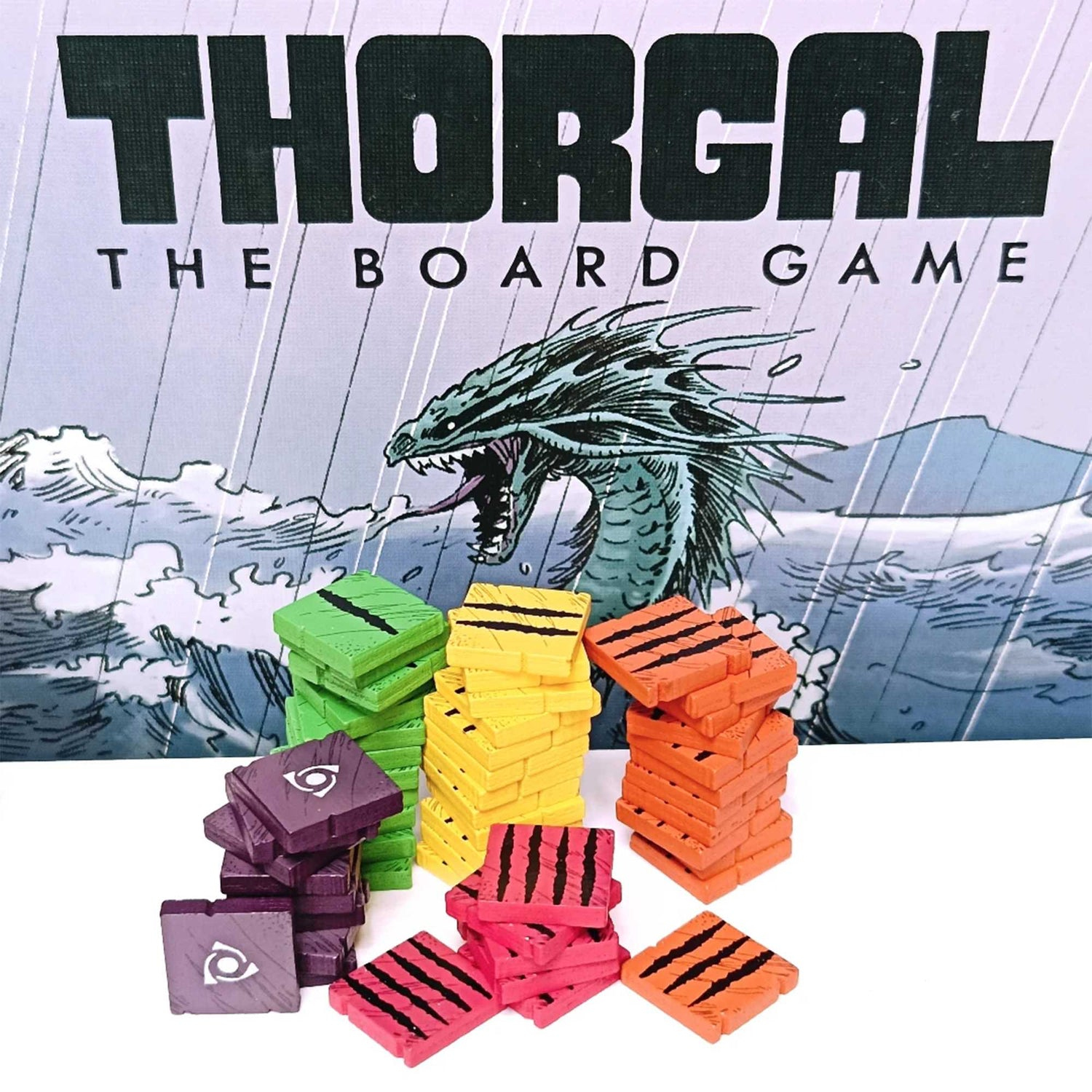Brettspielbox für Thorgal. Bunte Holzspielsteine sind vor der Box gestapelt. Ein Drache ist auf dem Box-Art zu sehen.