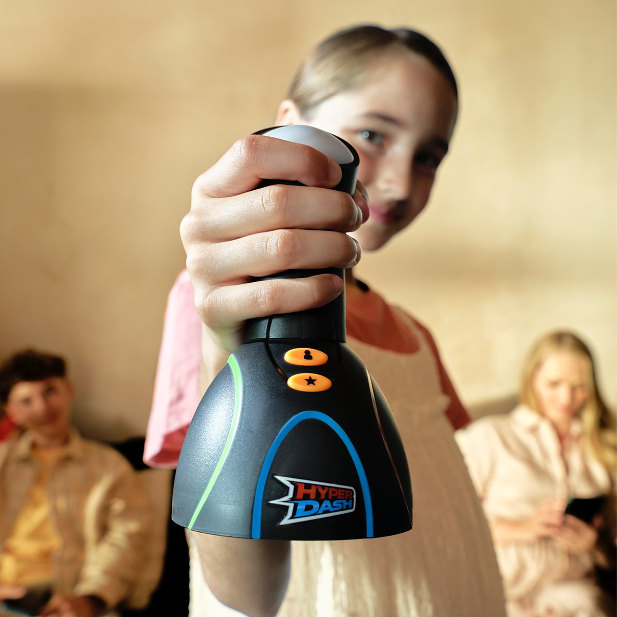 Een meisje houdt een zwart Hyper Dash-spel vast. Twee andere mensen zijn wazig op de achtergrond. Het spel wordt naar de camera gehouden.