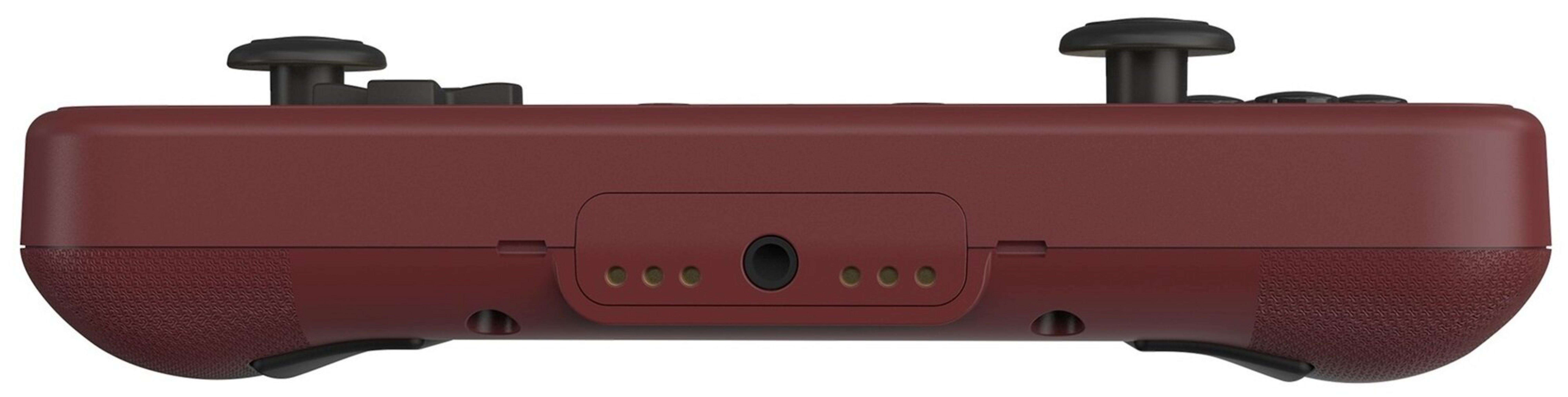Un controller di gioco bordeaux. Ha joystick e pulsanti neri. C'è un jack per le cuffie al centro.