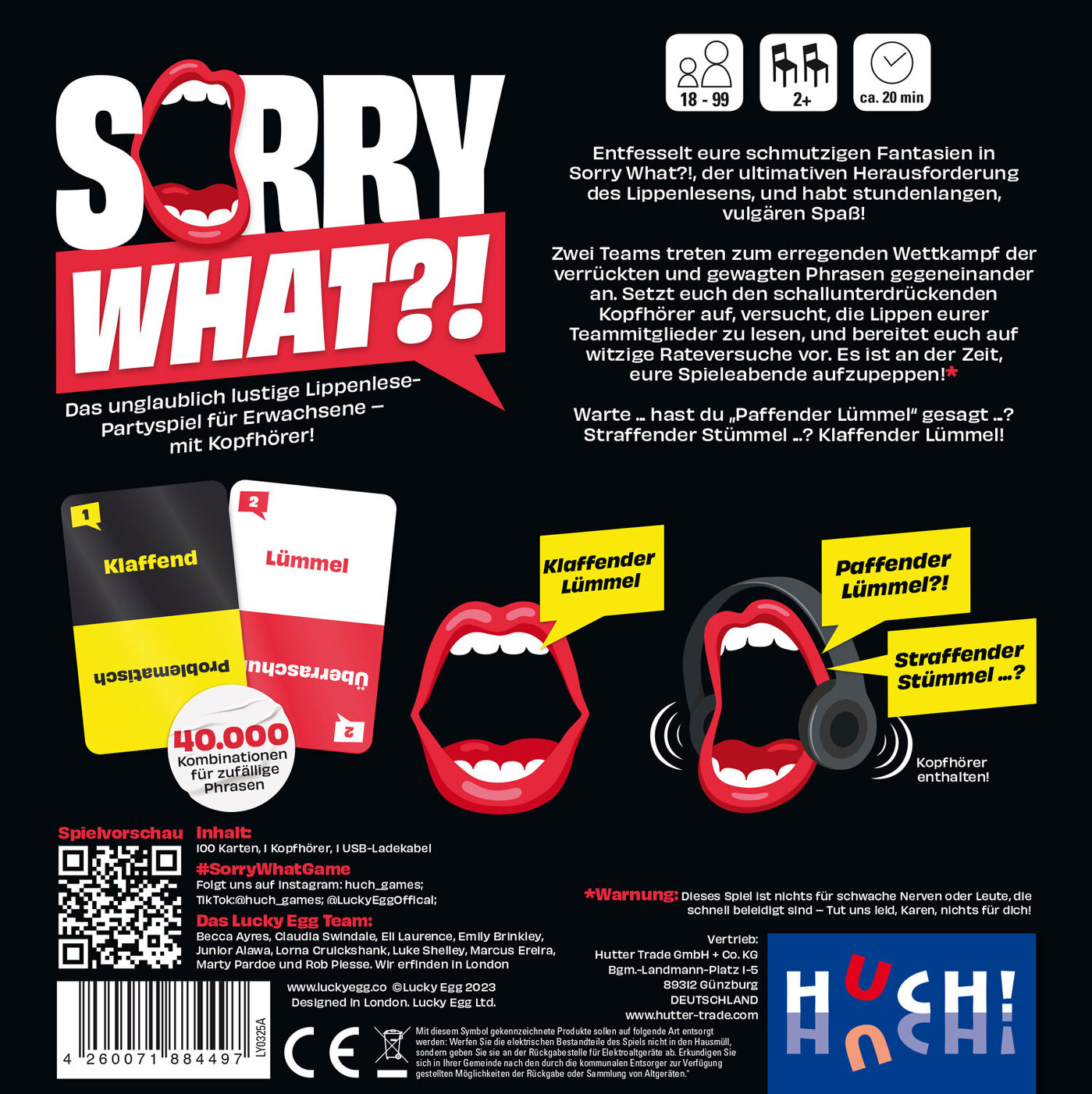 Scatola di gioco, grafica bocca rossa, titolo Sorry What?! Due carte, cuffie e testo in tedesco.