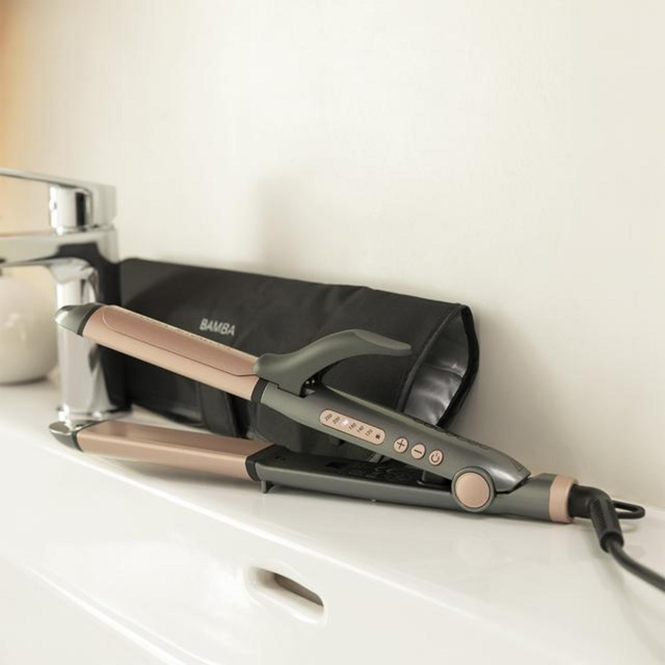 Prostownica do włosów i czarna torba na białej powierzchni. Z tyłu widoczna jest bateria.