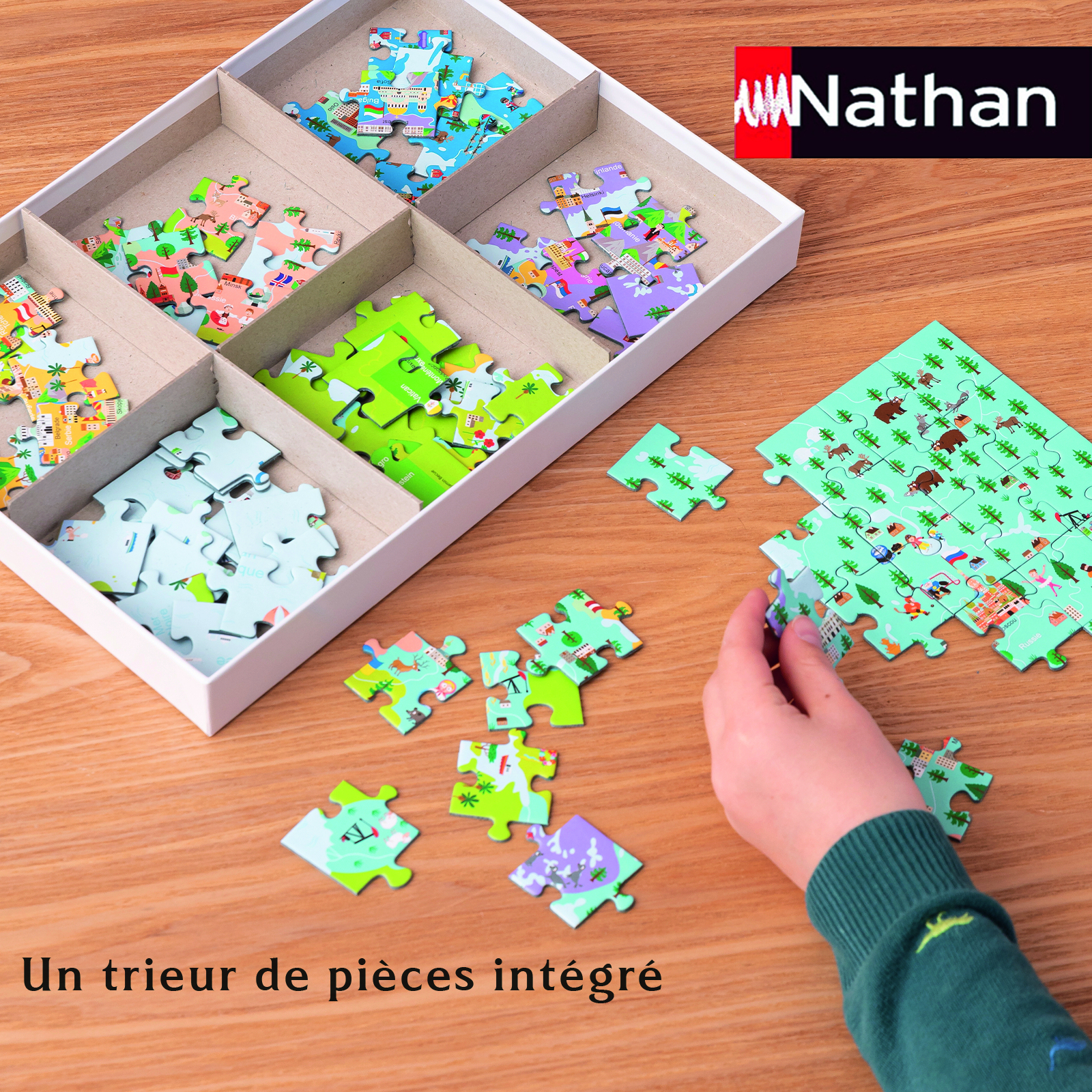 Eine Hand legt ein Puzzleteil auf ein größeres Puzzle. Das Puzzle hat mehrere Farben und eine Schale hält andere Teile.