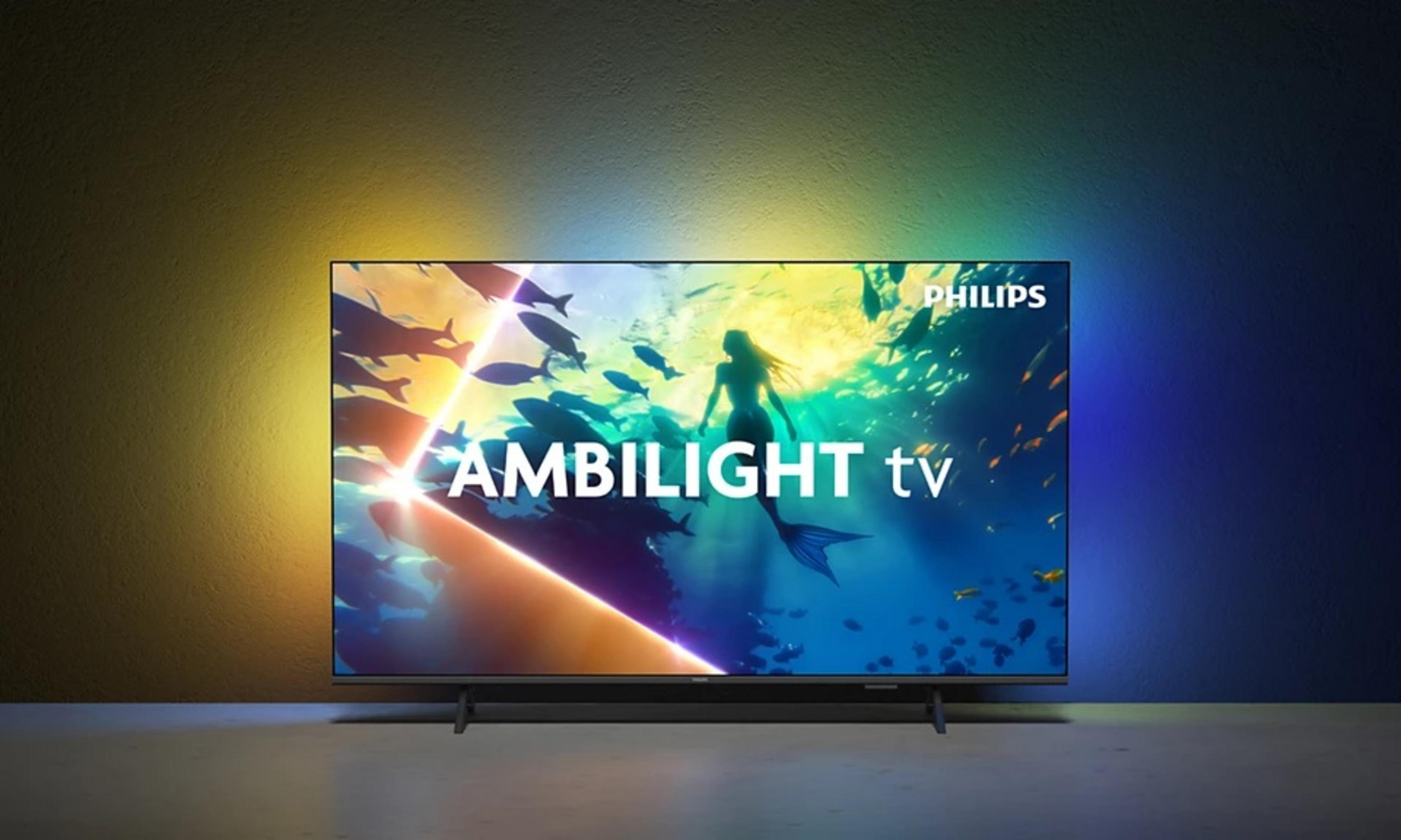 Un televisor Philips Ambilight muestra una escena submarina con una sirena y peces. El fondo tiene un degradado de colores.