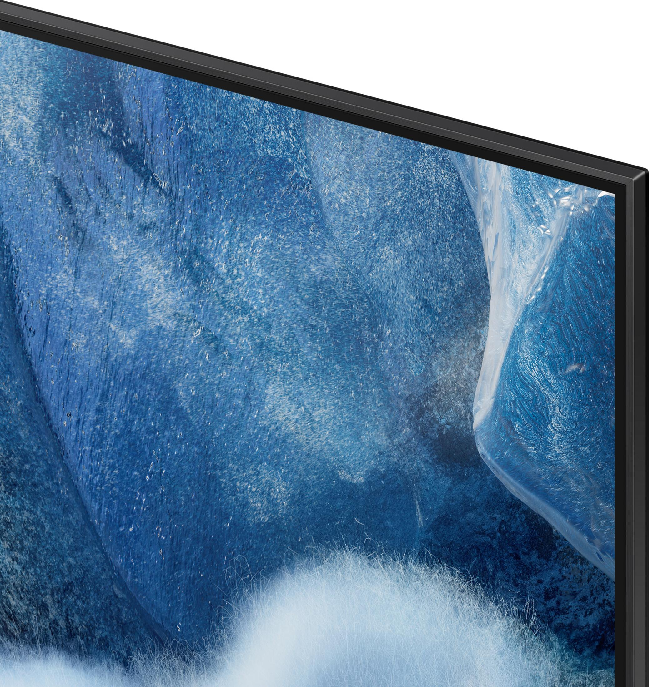 Primo piano di uno schermo TV con design blu astratto e cornice nera. Forma bianca simile a una nuvola in basso.