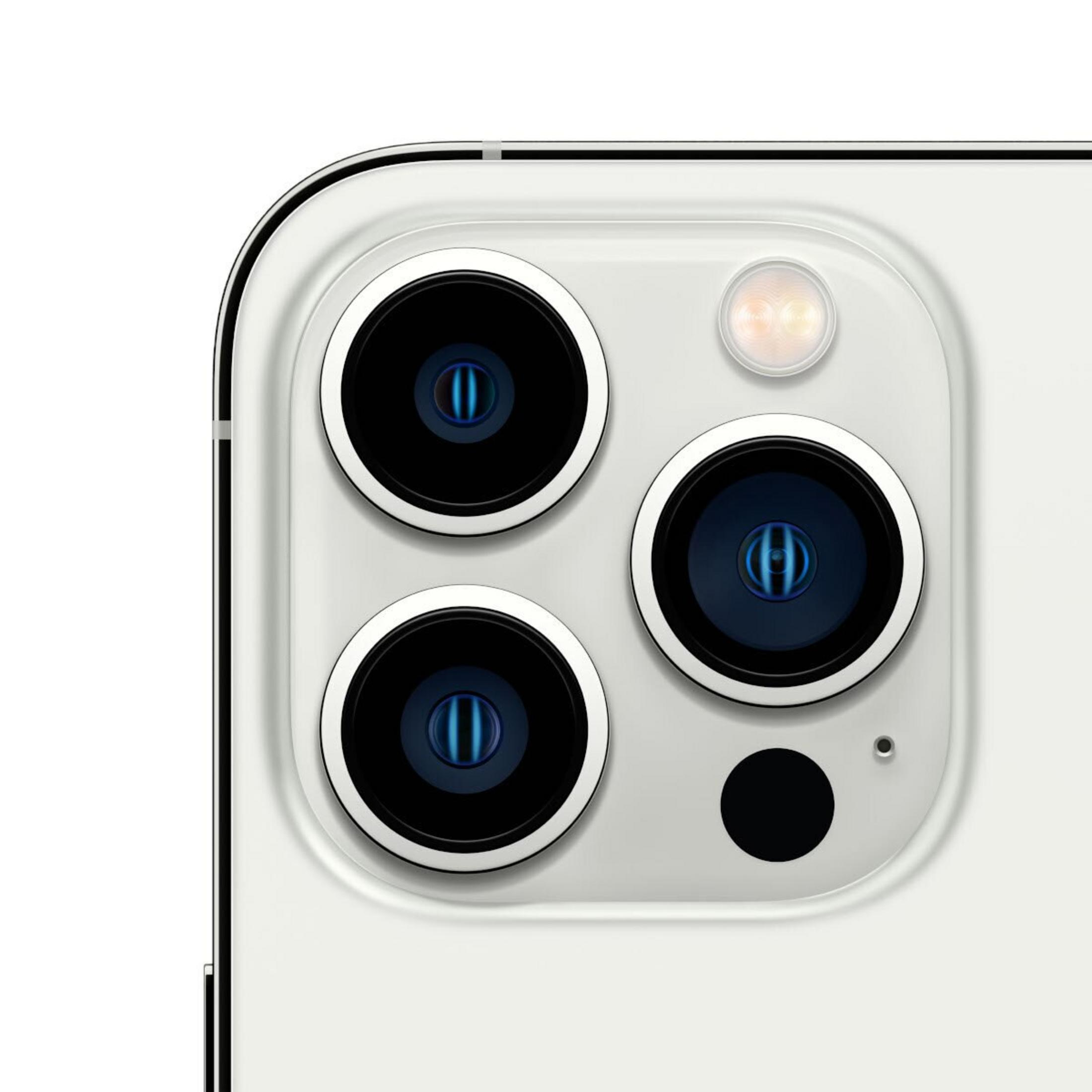 Primo piano di un modulo fotocamera di smartphone con tre lenti, un flash e un punto nero, il tutto su una superficie bianca.
