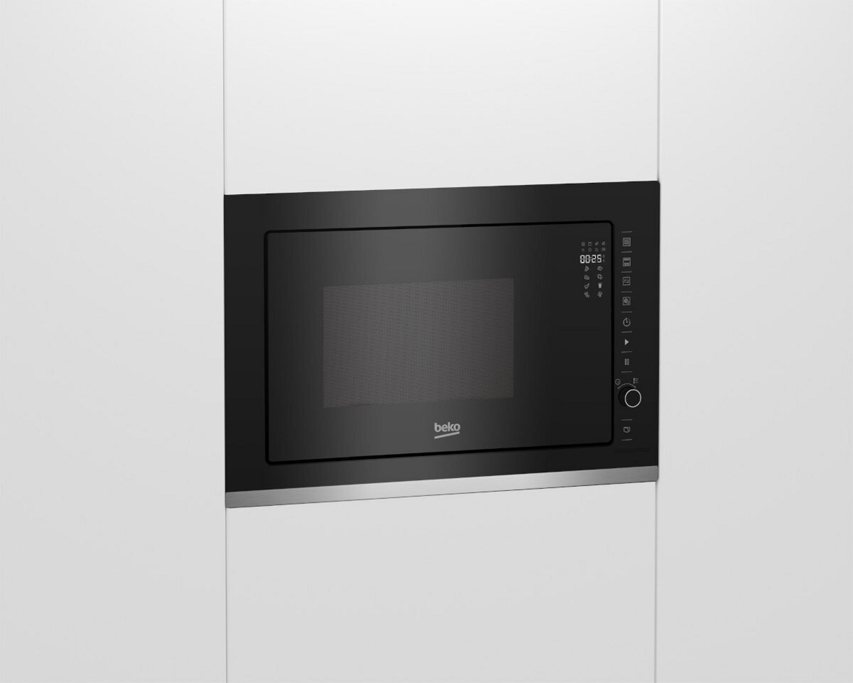 Un forno a microonde Beko nero è integrato in un mobile bianco. Il microonde ha un display digitale e un pannello di controllo.