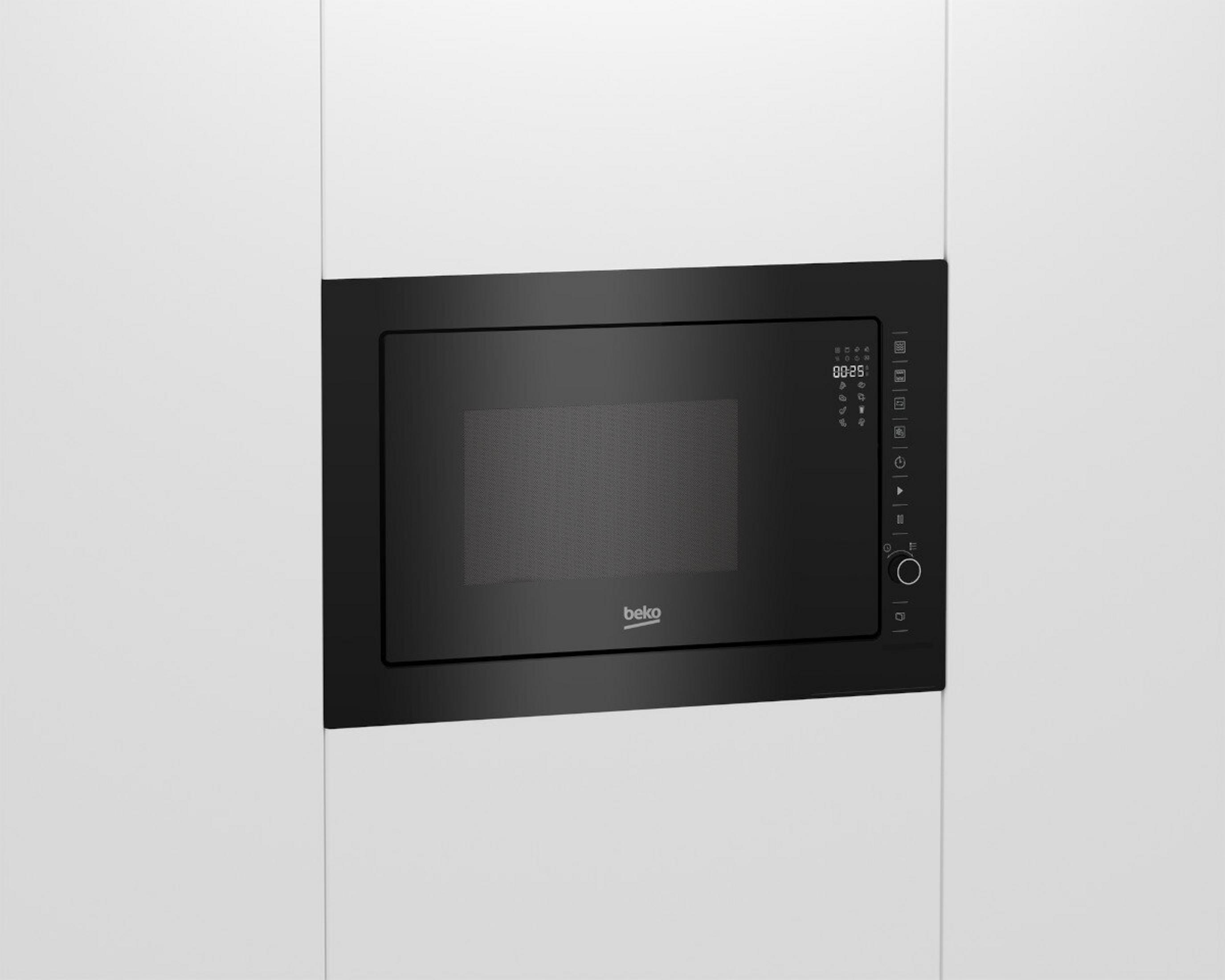 Un forno a microonde Beko nero è integrato in un mobile bianco. Il display mostra 00:25.