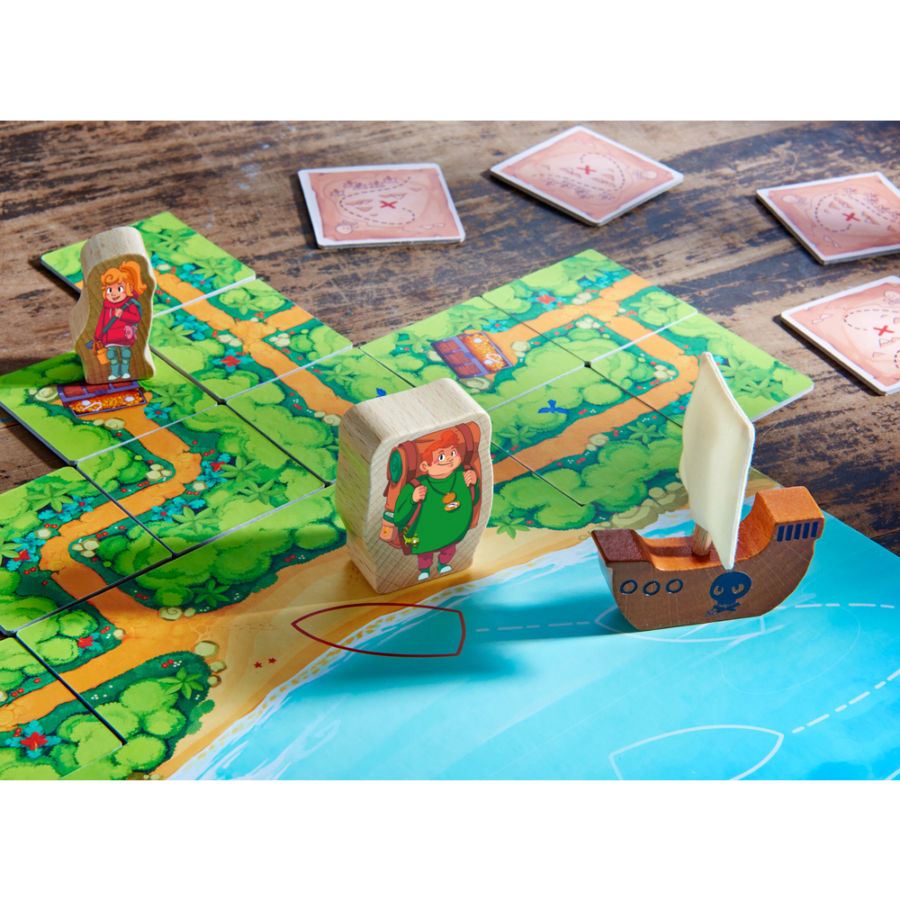 Brettspiel mit Holzfiguren auf einem Weg. Ein Boot und Karten sind vorhanden. Das Spielbrett ist grün mit Schatzkarten-Motiv.