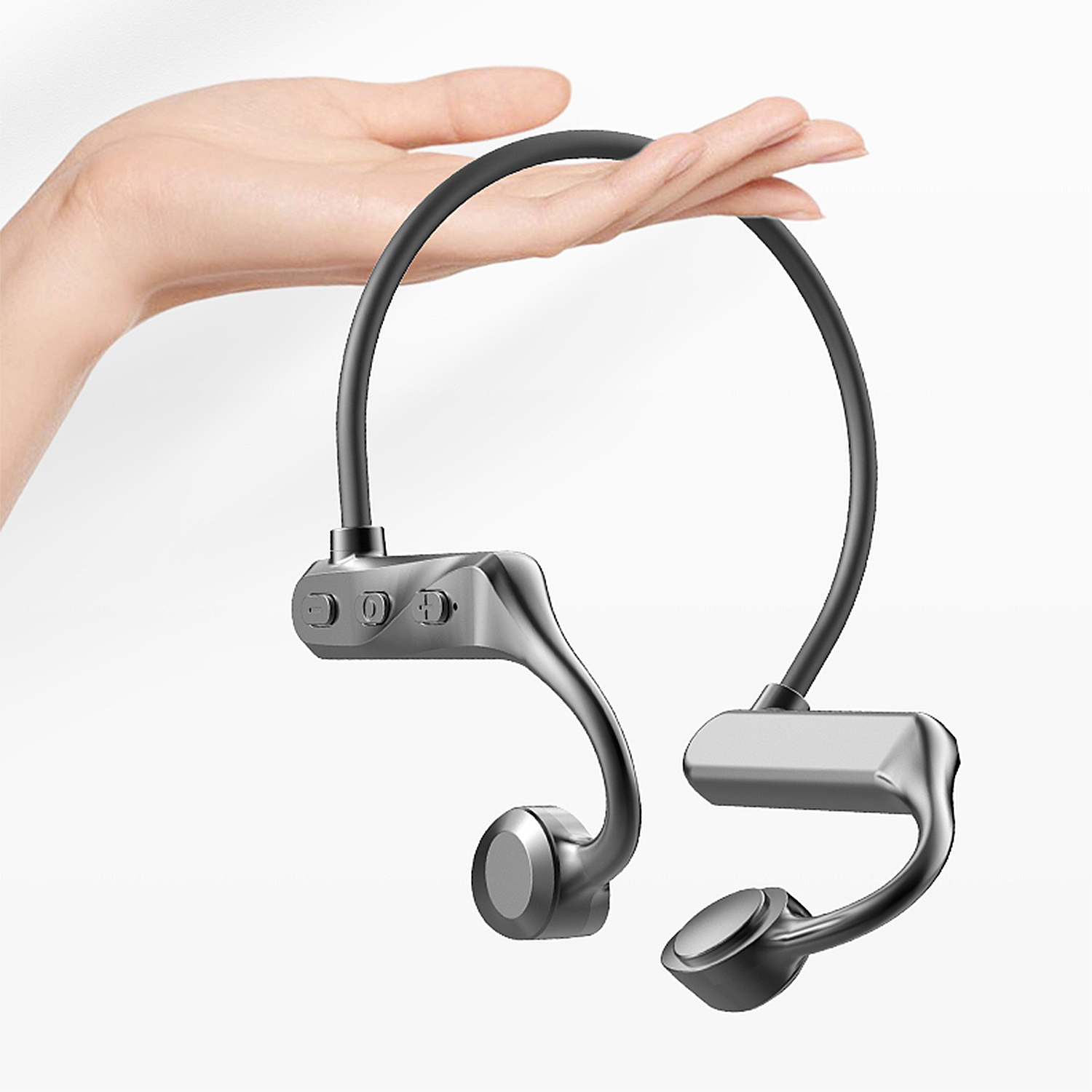 Una mano tiene un'auricolare a conduzione ossea argentata con fascia nera. I pulsanti sono visibili. Sfondo bianco.
