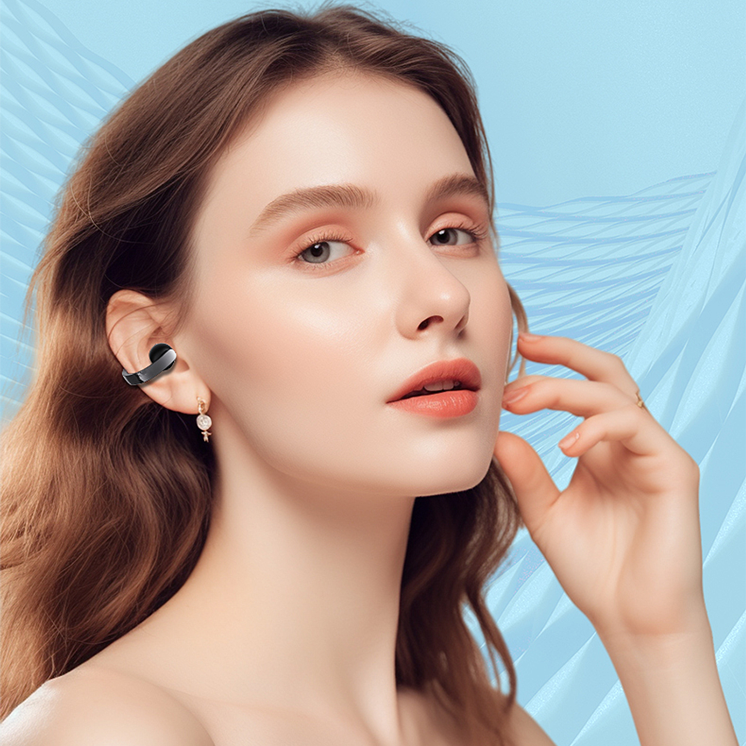 Una donna con capelli castani ondulati, indossa un auricolare. Si tocca il viso. Lo sfondo è azzurro con linee bianche.