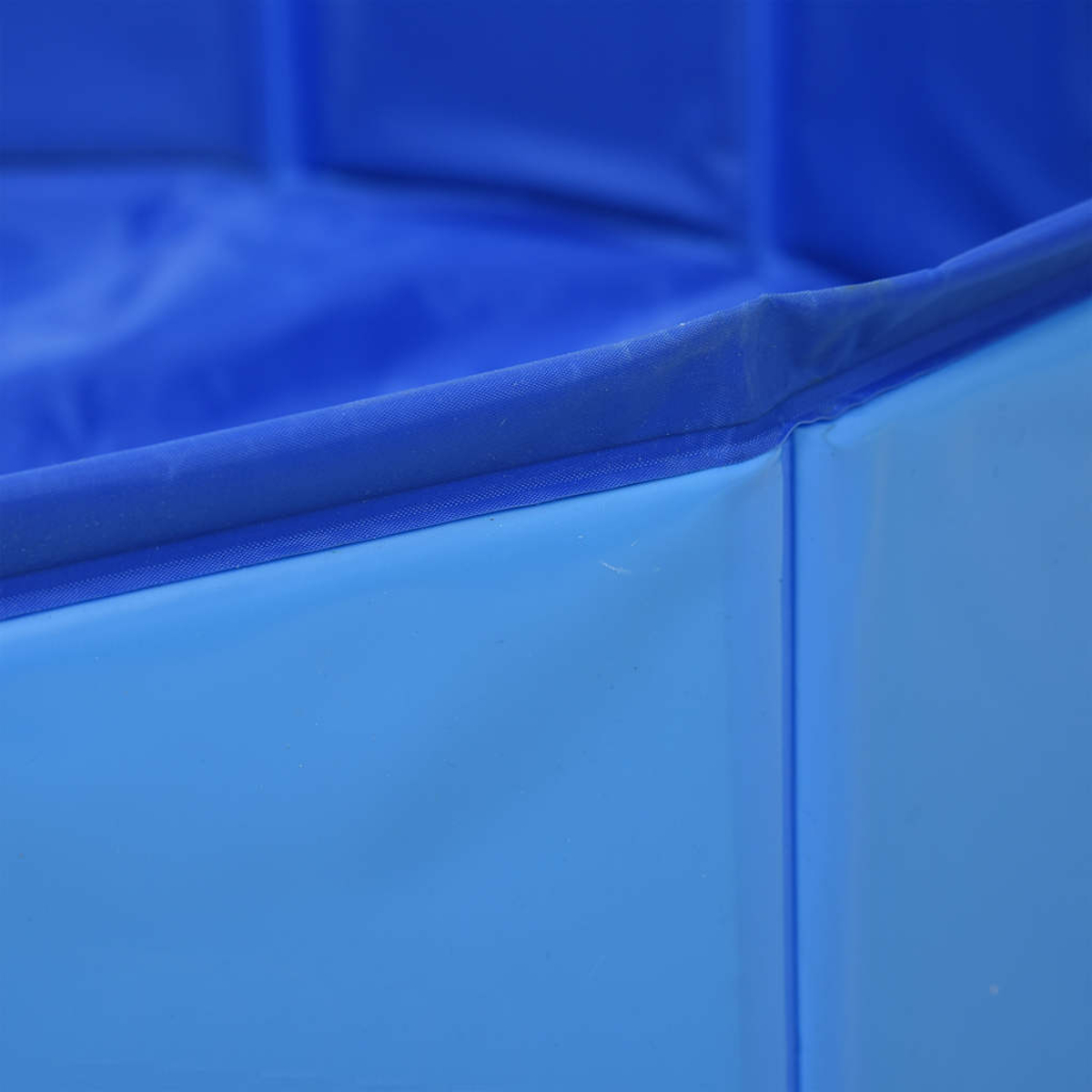 Nahaufnahme eines blauen, zusammenklappbaren Pools. Die Seiten des Pools sind sichtbar und zeigen eine hellblaue Außenseite und eine dunkelblaue Innenseite.
