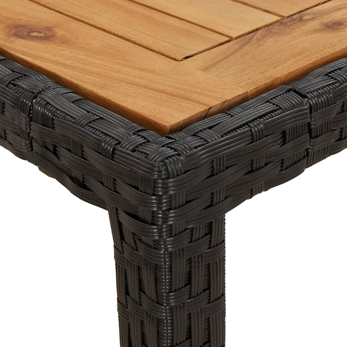 Nahaufnahme eines Tisches. Er hat eine Holzplatte und einen dunklen, gewebten Sockel. Die Ecke ist sichtbar, zeigt das Design.