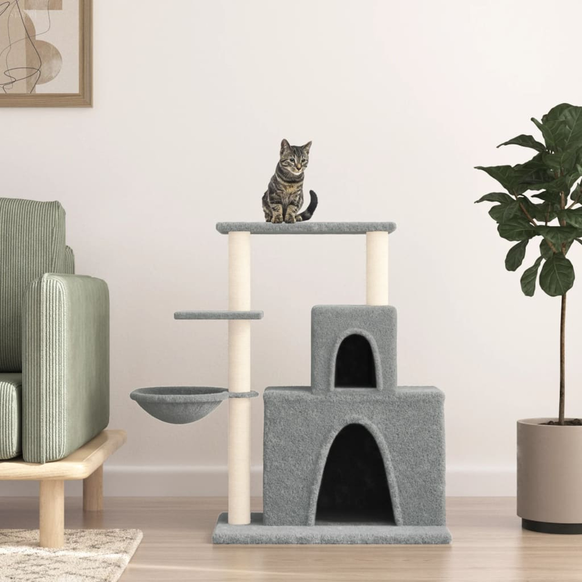 Eine Katze sitzt oben auf einem grauen Kratzbaum. Eine Topfpflanze steht rechts. Ein Sofa und ein gerahmtes Kunstwerk sind links.