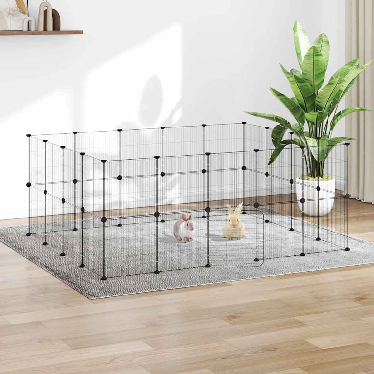 Zwei Kaninchen in einem Drahtgehege auf einem Teppich. Eine große Topfpflanze befindet sich rechts. Holzfußboden.