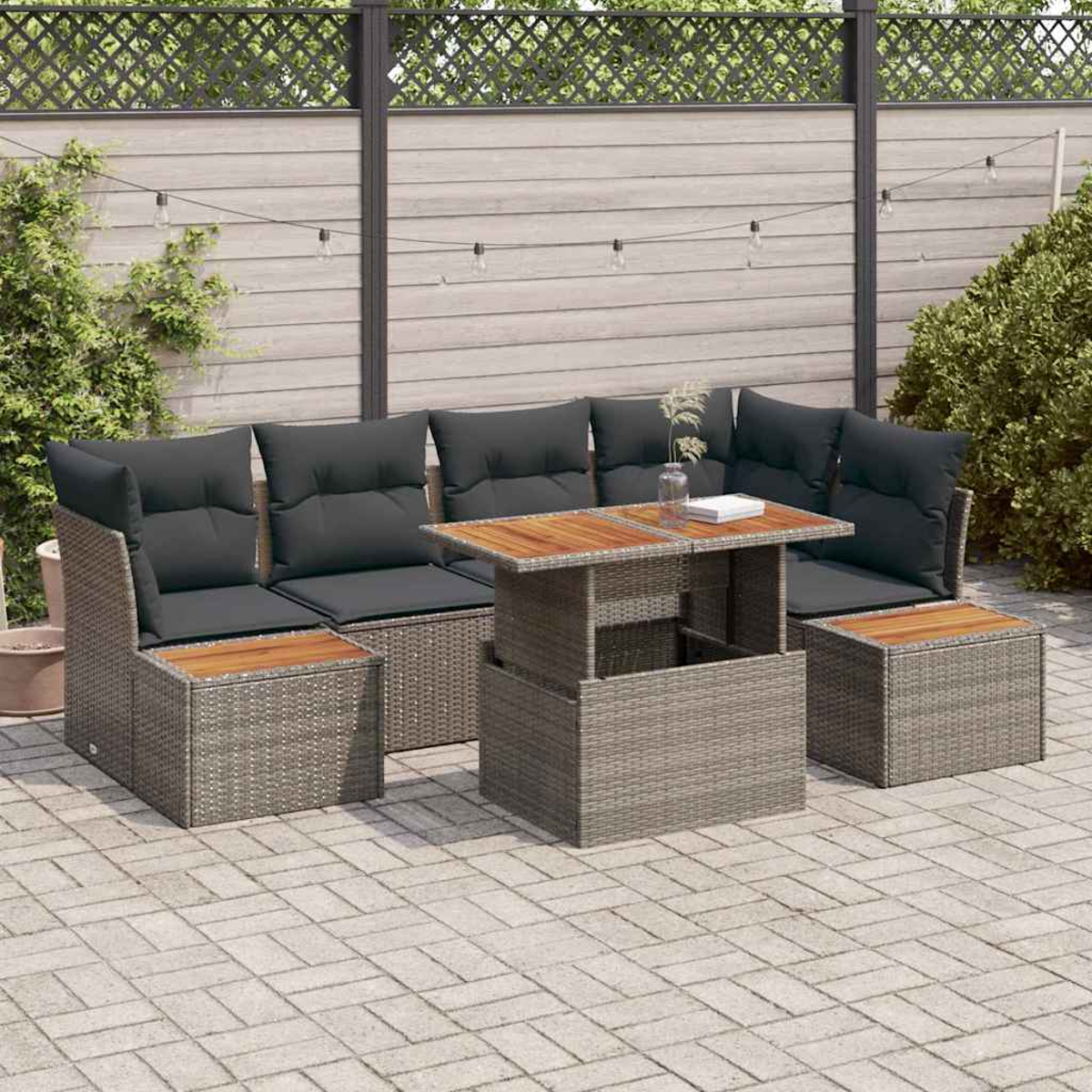 Garten-Ecksofa mit grauen Kissen und Holztisch auf einer gepflasterten Terrasse. Im Hintergrund ein Holzzaun und Grün.