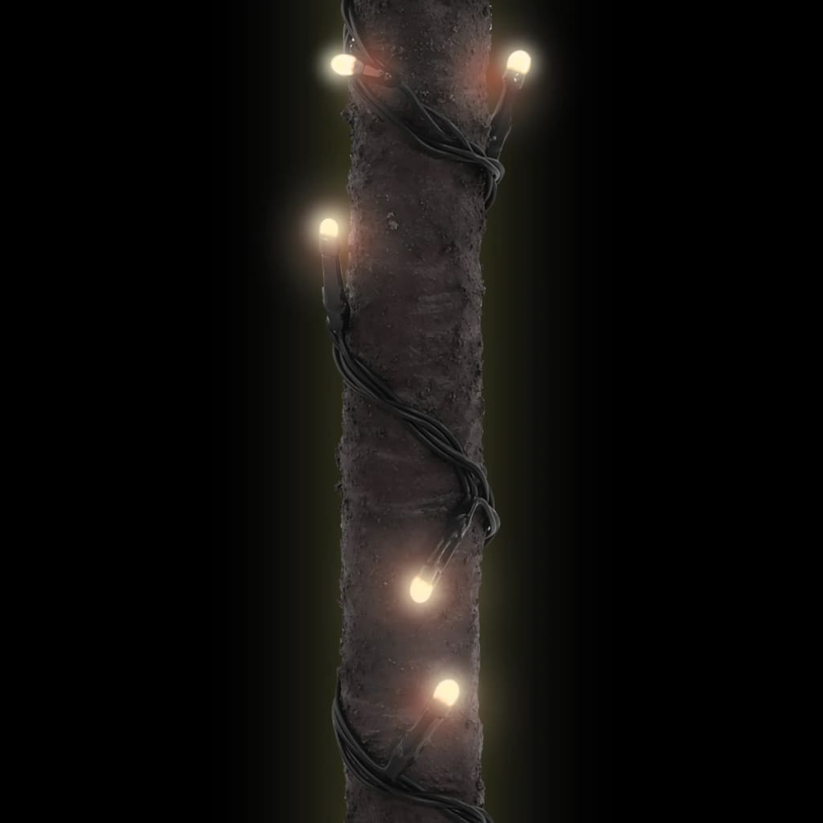 Ein dunkler Baumstamm mit Lichterketten. Die Lichter sind gelb und der Hintergrund ist schwarz.