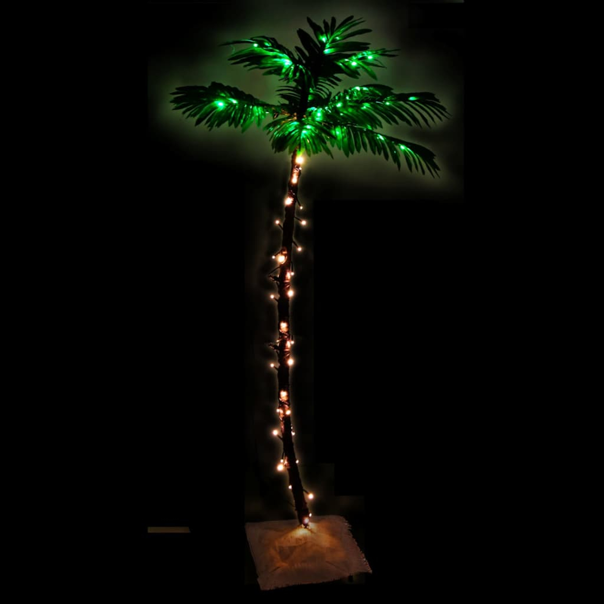 Eine dekorative Palme mit grünen Blättern und Lichtern. Der Stamm hat Lichterketten. Sie steht auf einem quadratischen Sockel, alles vor Schwarz.