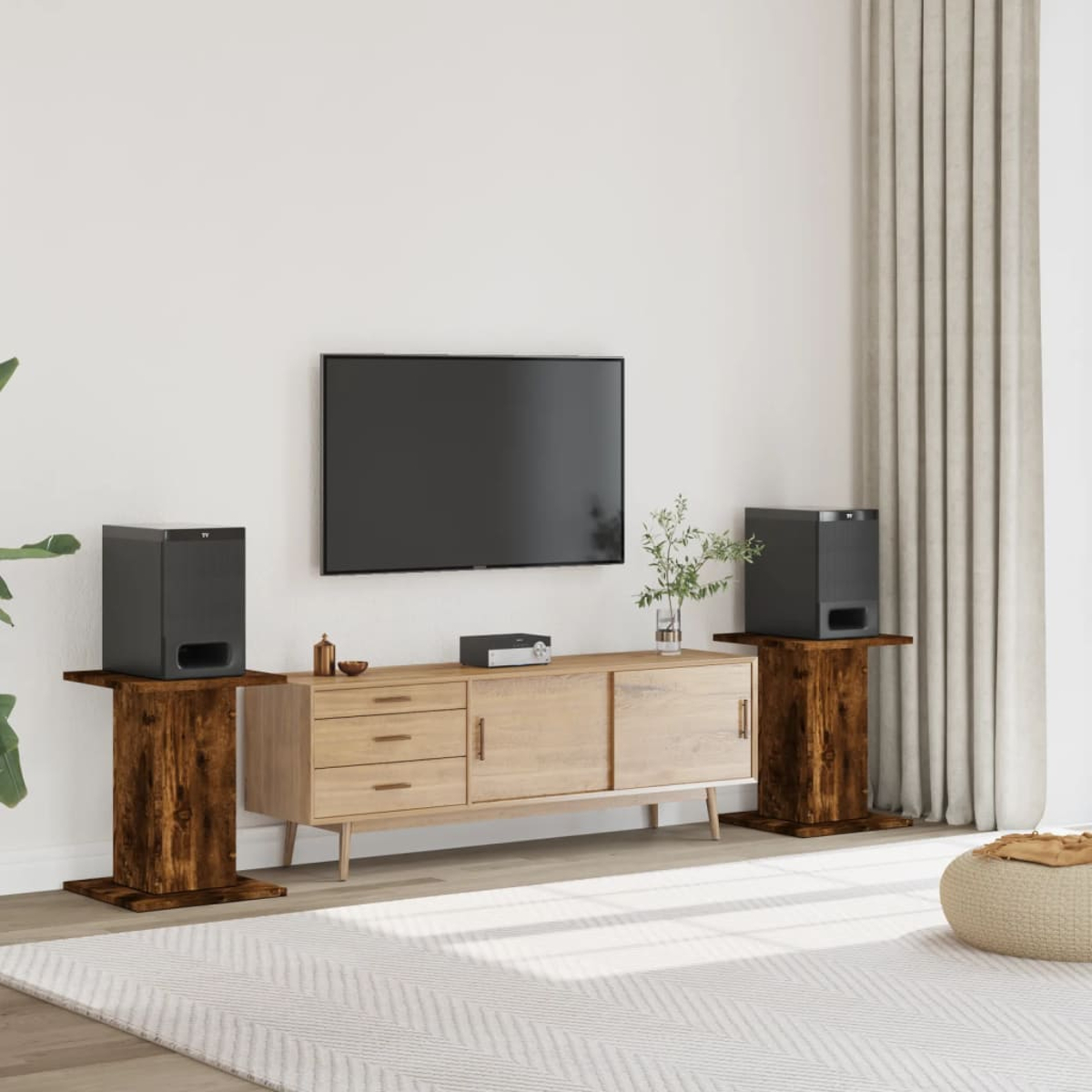 Wohnzimmer-Setup mit Fernseher, Lautsprechern auf Holzständern, Schrank, Teppich und Vorhang.