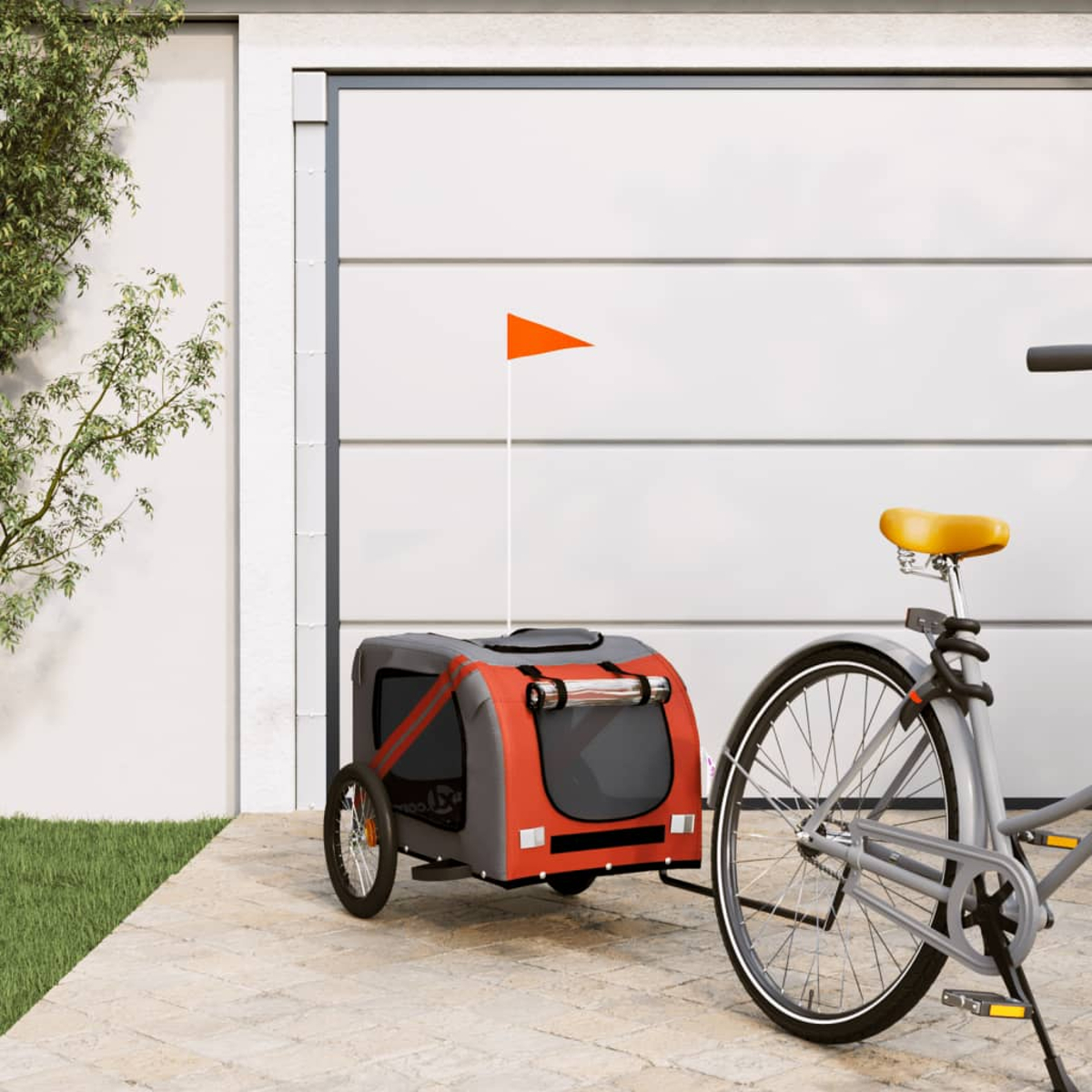Fahrrad mit Tieranhänger. Der Anhänger ist rot und grau mit einer orangefarbenen Fahne. Das Fahrrad hat einen gelben Sitz. Der Hintergrund ist eine Garage.