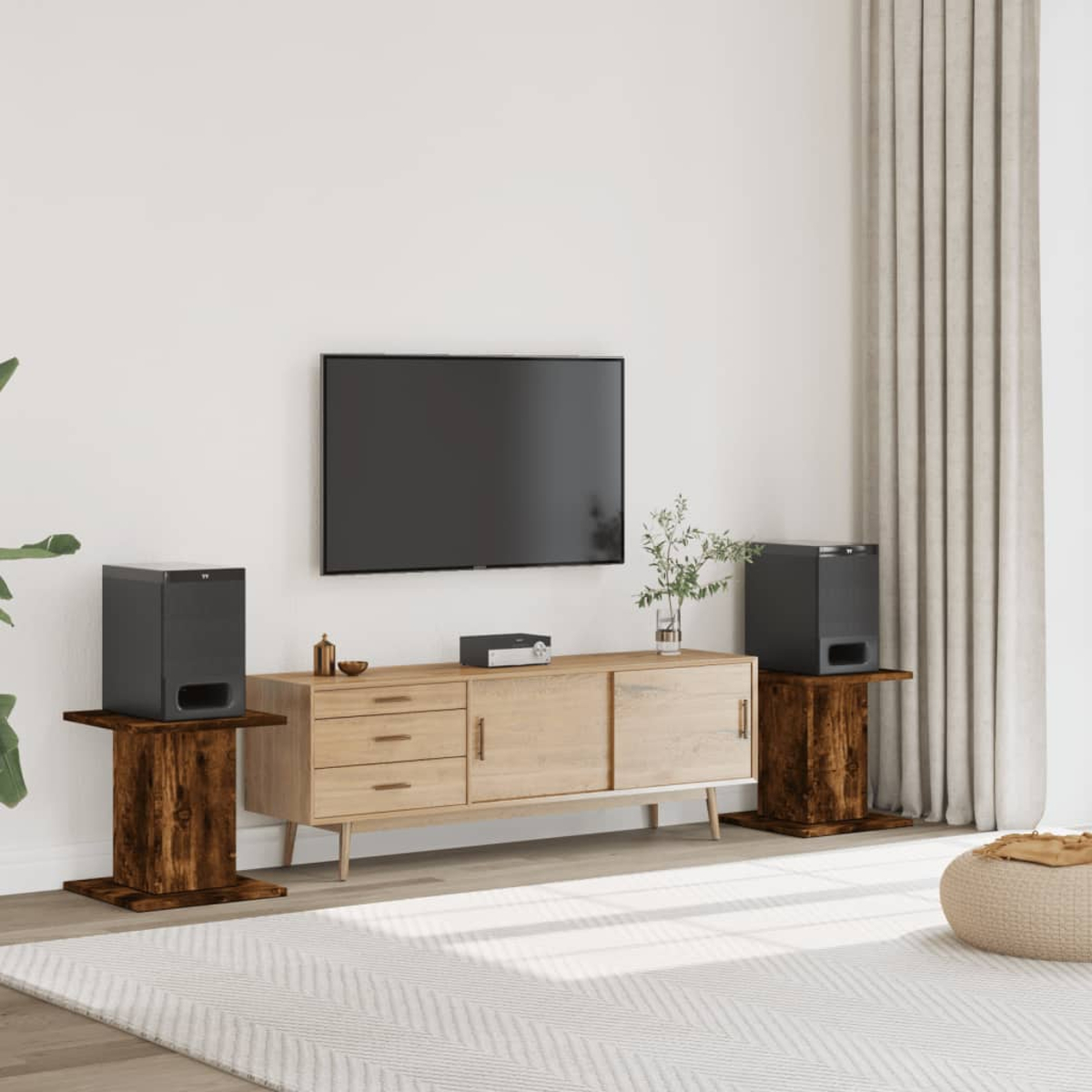 Wohnzimmer mit Fernseher, Lautsprechern auf Holzständern, hellem Schrank und Teppich. Vorhänge im Hintergrund.