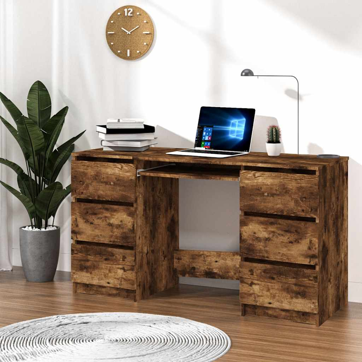 Ein hölzerner Schreibtisch mit Laptop, Pflanze, Uhr und Büchern. Auf dem Boden liegt ein Teppich. Der Hintergrund ist eine weiße Wand.