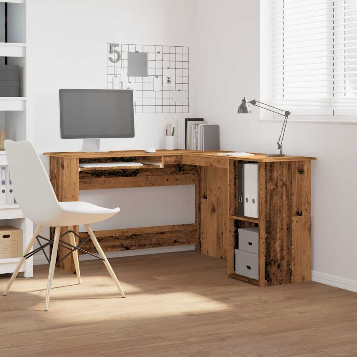 Ein hölzerner Eckschreibtisch mit Computer, Stuhl und Lampe. An der Wand befindet sich eine Gittertafel. Der Boden ist aus Holz.
