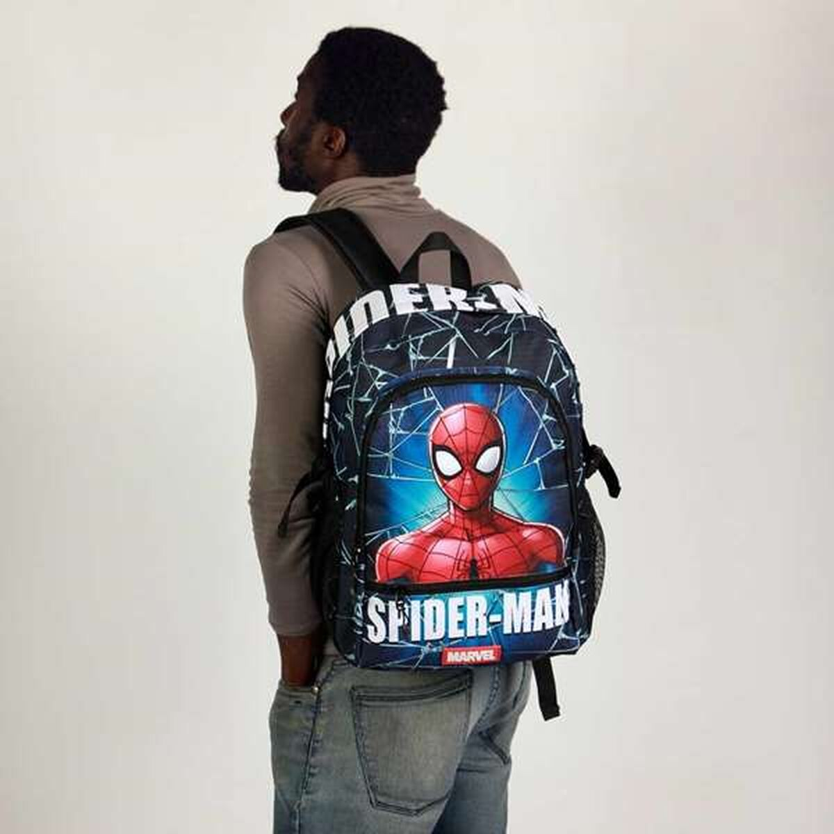 Ein Mann mit einem Spider-Man-Rucksack. Der Rucksack zeigt Spider-Mans Gesicht und die Worte 'Spider-Man' auf blauem Grund.
