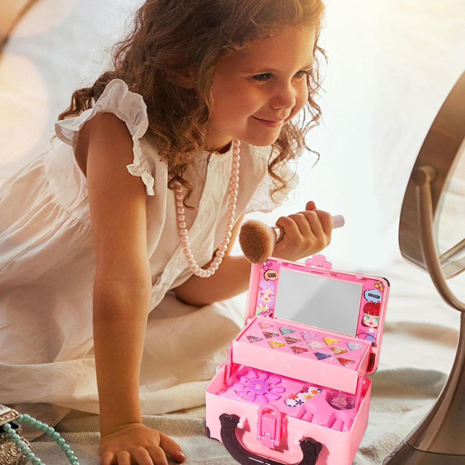 Ein Mädchen blickt in einen Spiegel und hält einen Make-up-Pinsel. Ein pinkfarbenes Make-up-Kit ist geöffnet. Sie trägt ein weißes Kleid und Perlen.