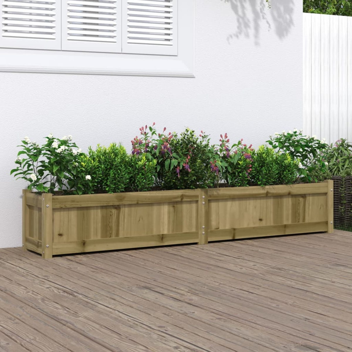 Zwei Holzpflanzkästen mit verschiedenen Blumen und Pflanzen stehen auf einer Holzterrasse. Im Hintergrund befinden sich eine weiße Wand und ein Fenster.