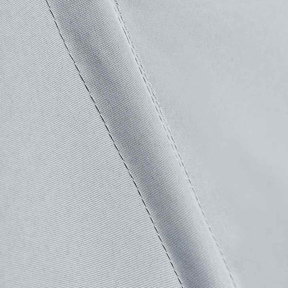 Nahaufnahme eines hellgrauen Stoffes mit diagonaler Steppung. Die Textur ist fein gewebt und der Stoff wirkt glatt.