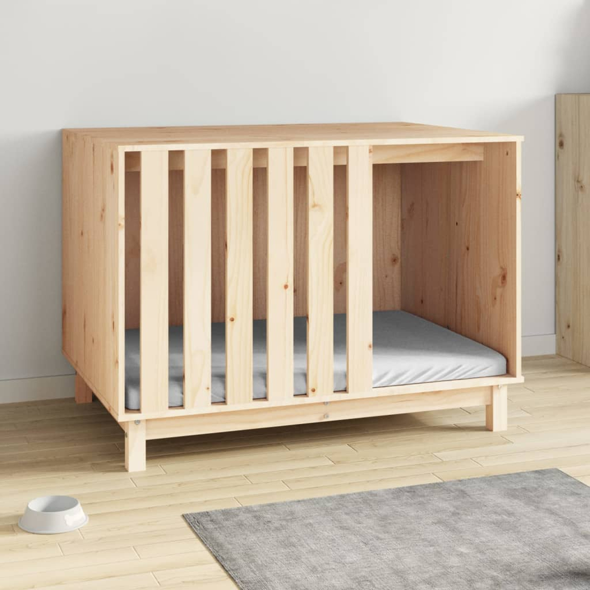 Ein hölzernes Hundehäuschen mit einem grauen Bett im Inneren, auf einem Holzboden mit einem grauen Teppich und einer weißen Schüssel.