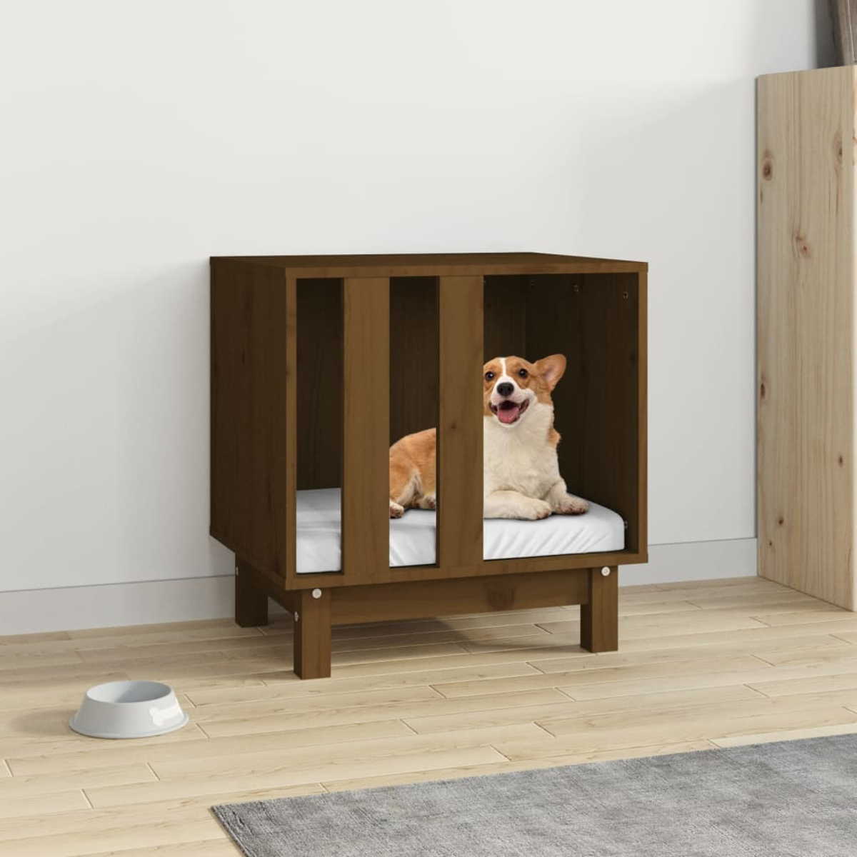 Ein Hund in einem Hundehäuschen aus Holz mit weißem Kissen. Eine Schüssel ist im Vordergrund. Der Hund ist braun und weiß.