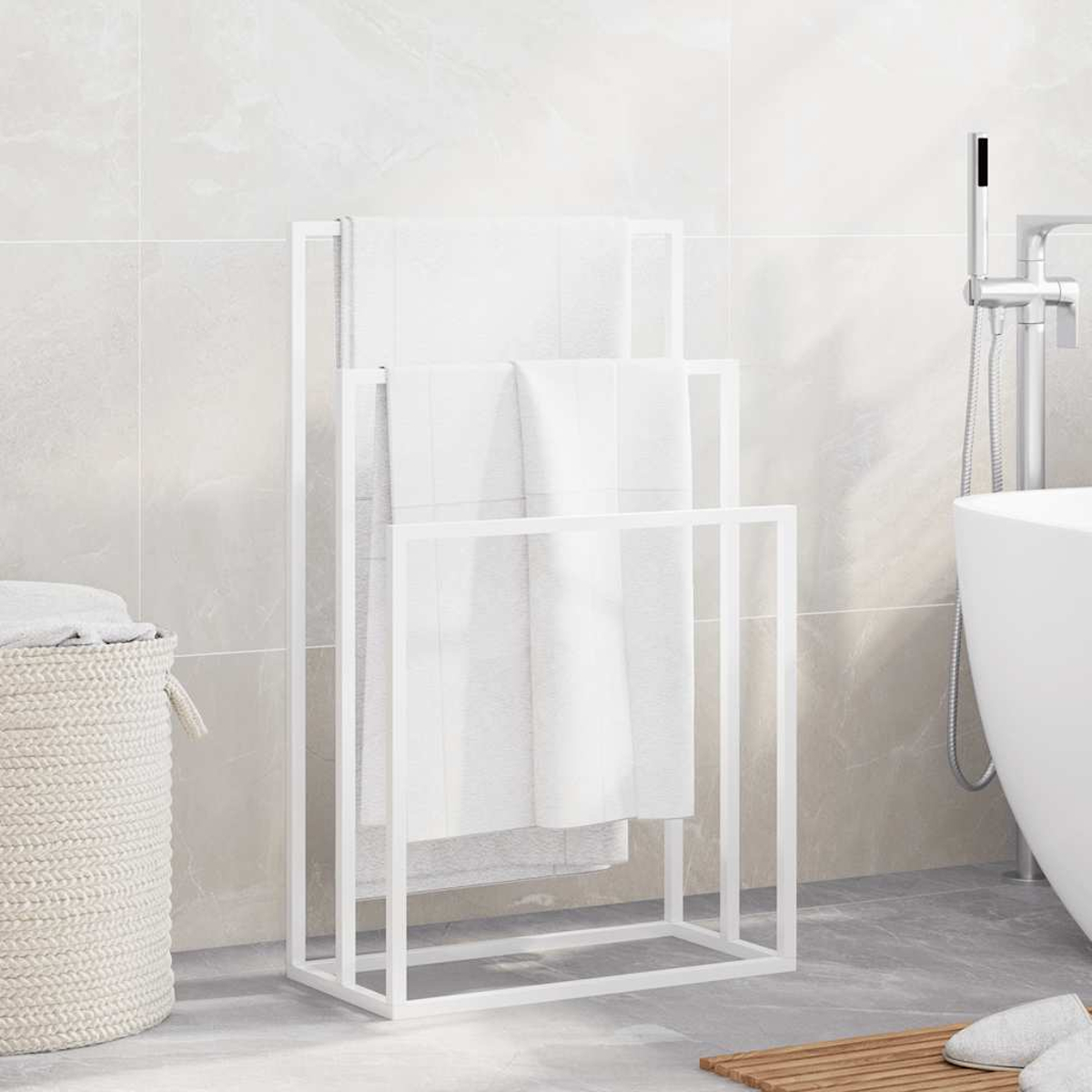 Weißer Handtuchhalter mit weißen Handtüchern in einem Badezimmer. Ein Korb und eine Badewanne sind im Hintergrund.