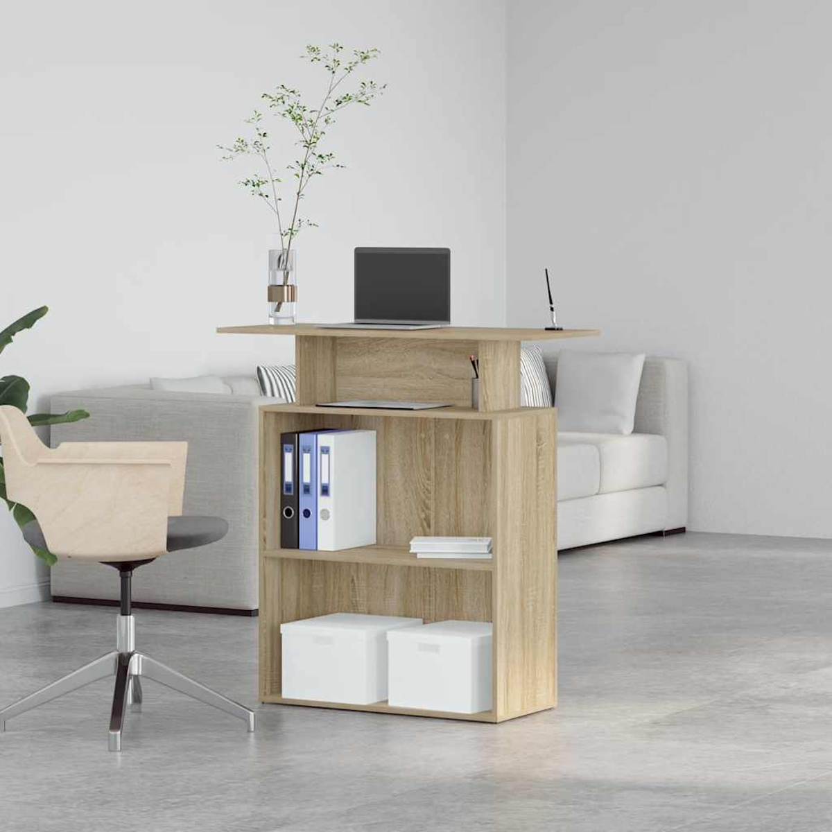 Ein Holzschreibtisch mit Laptop, Akten und einer Vase mit Grün. Ein Stuhl und ein Sofa sind im Hintergrund.
