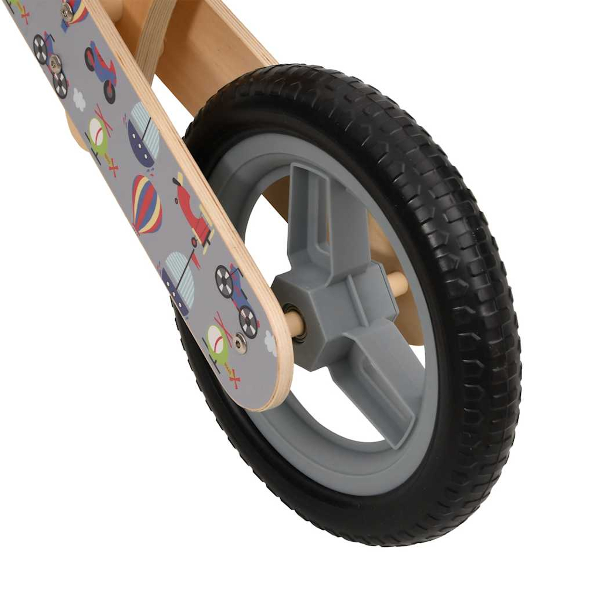 Nahaufnahme eines Laufrads. Fokus auf Vorderrad, graue Felge, schwarzer Reifen. Rahmen helles Holz mit Fahrzeugdrucken.