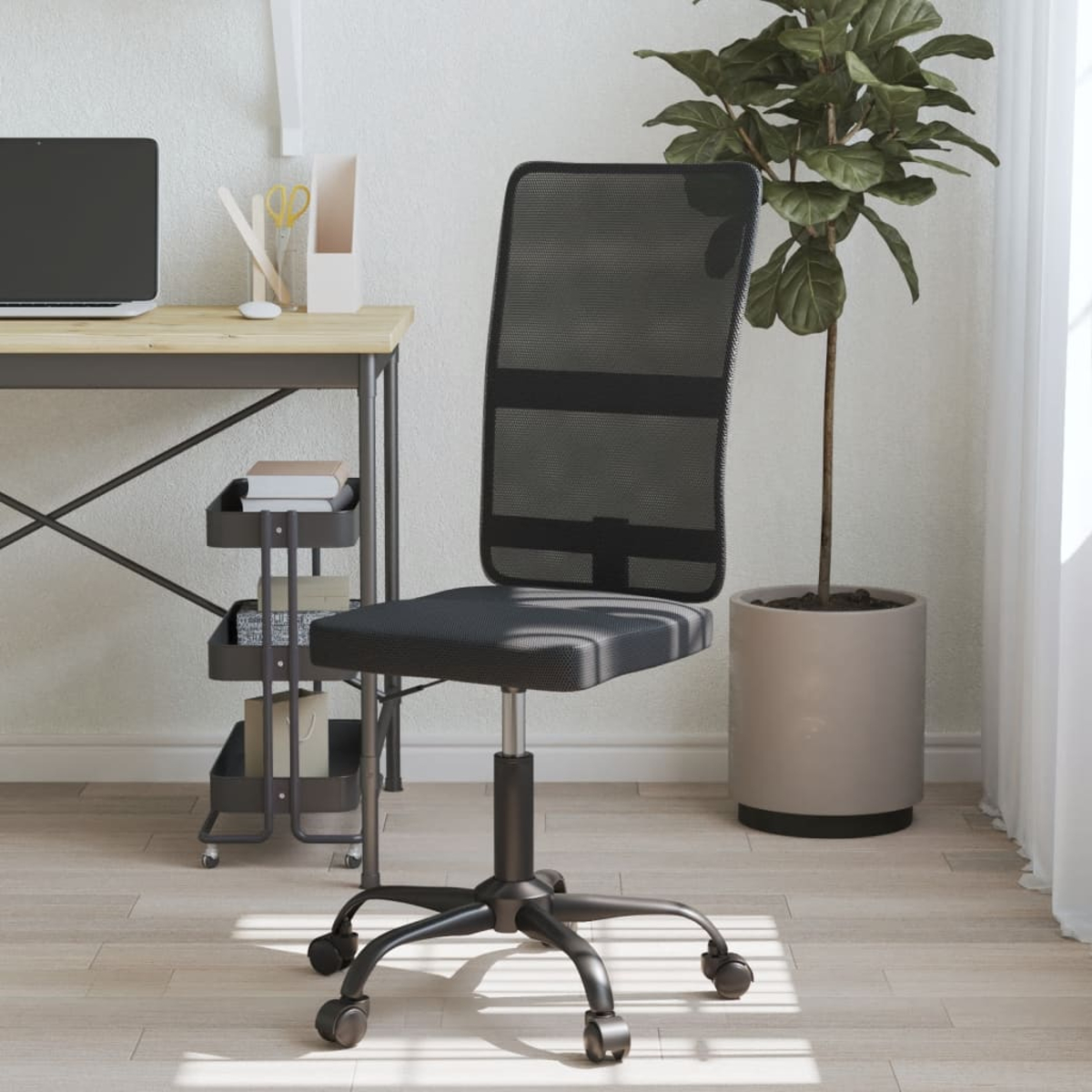 Ein schwarzer Bürostuhl mit Netzrücken steht vor einem Schreibtisch, rechts ein Topf mit Pflanze. Laptop und Schreibtischzubehör sind sichtbar.