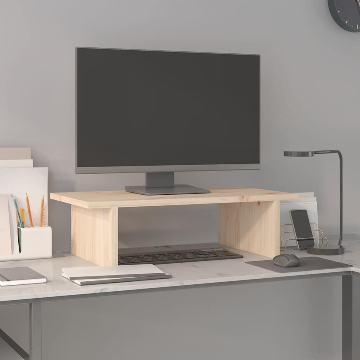 Ein Computermonitor steht auf einem Holzständer über einer Tastatur. Der Schreibtisch hat eine Lampe, ein Telefon, eine Maus und Schreibwaren.