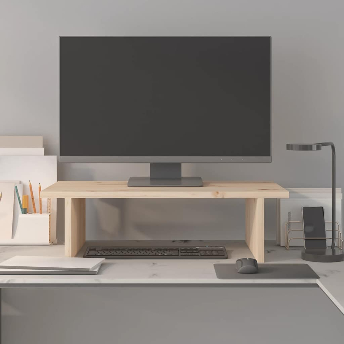 Ein Computermonitor steht auf einem Holzständer. Tastatur und Maus befinden sich auf dem Schreibtisch. Eine Lampe, ein Telefon und Schreibwaren sind ebenfalls vorhanden.