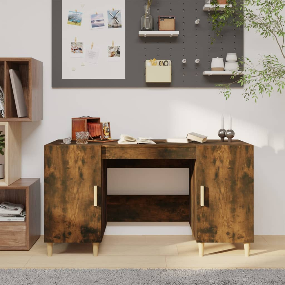 Ein hölzerner Schreibtisch mit Schränken und einem zentralen offenen Bereich. Eine Pinnwand mit Bildern an der Wand. Zubehör liegt auf dem Schreibtisch.