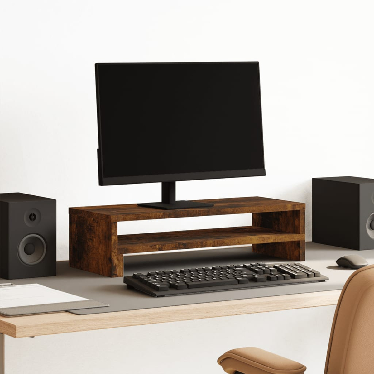 Ein Computer-Setup mit Monitor auf einem Holzständer, Tastatur, Lautsprechern und einer Maus auf einem Schreibtisch.