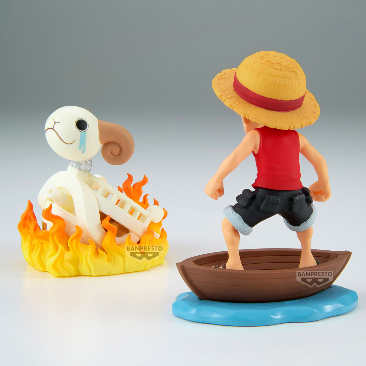 Una statuetta di Luffy in piedi su una barca. Una statuetta di agnello in fiamme e piangente è accanto a Luffy.