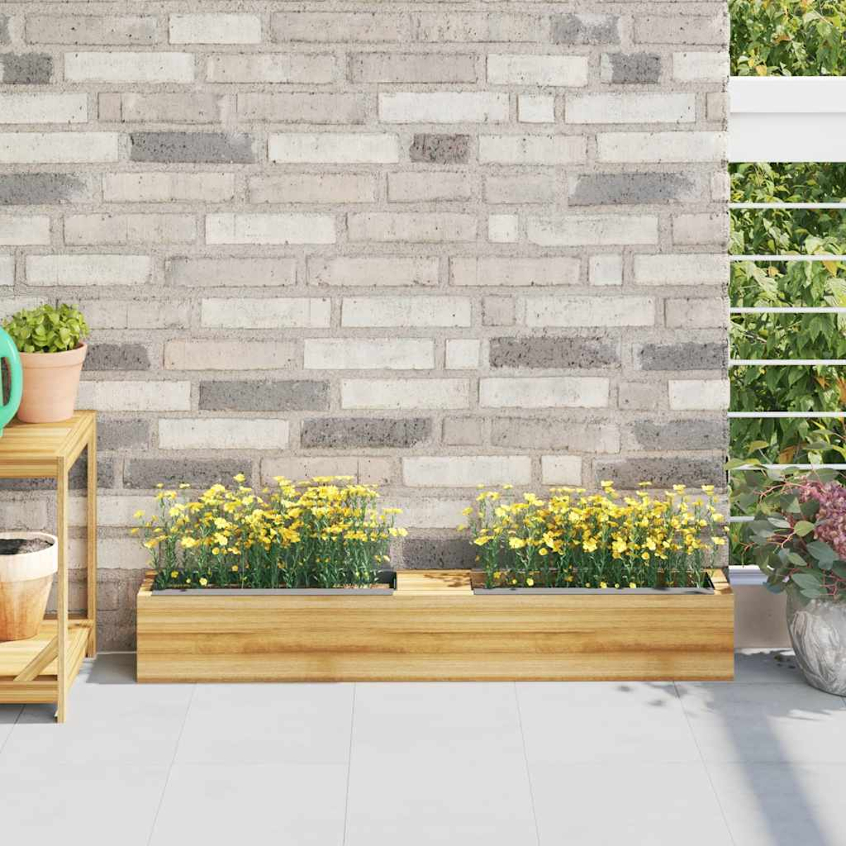 Holzpflanzkasten mit gelben Blumen. Ziegelmauer im Hintergrund. Pflanzen in Töpfen an der Seite. Weißer Boden.