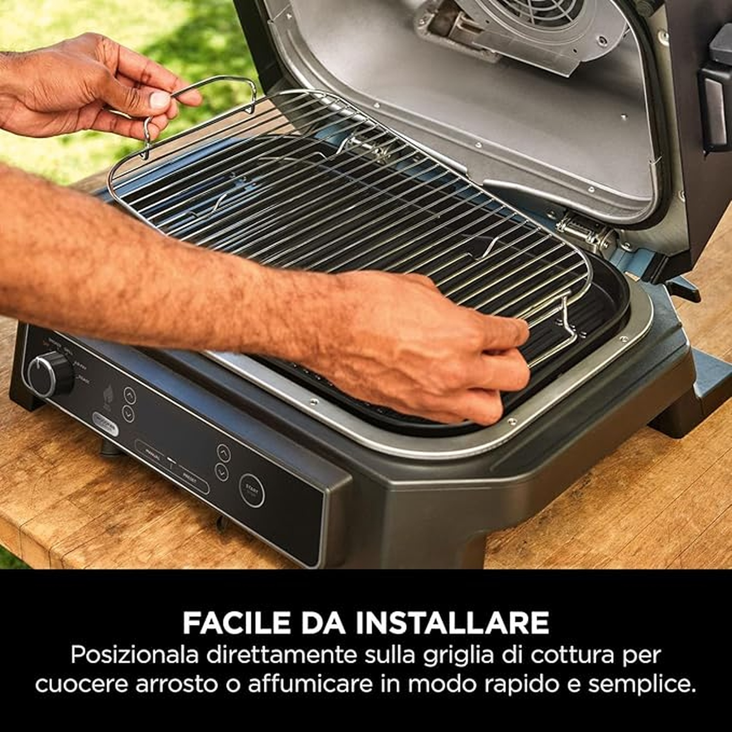 Eine Person legt einen Grillrost in einen schwarzen Grill. Der Grill steht auf einer Holzoberfläche. Der Text unten lautet 'Einfach zu installieren'.