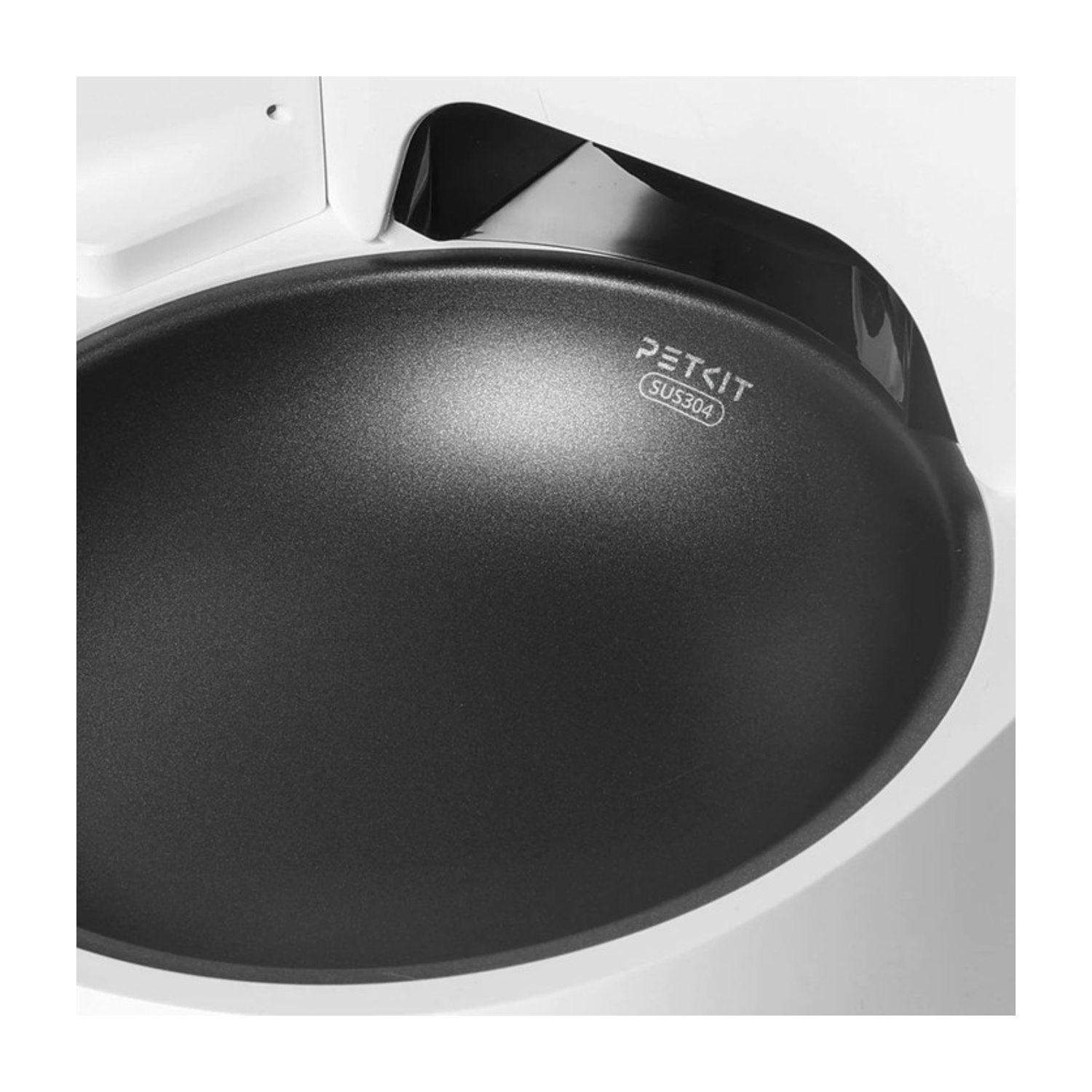 Zbliżenie miski dla zwierząt Petkit. Miska jest ciemnoszara, z nazwą marki i 'SUS304'. Otacza ją białe tworzywo sztuczne.