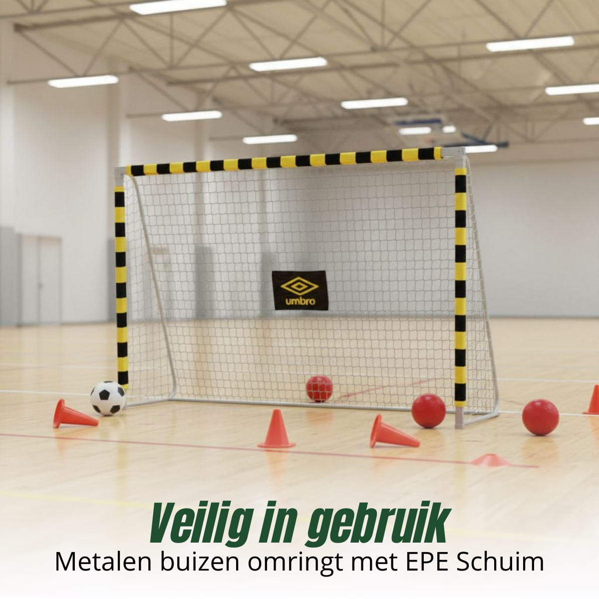A futsal goal with a net, soccer balls, orange cones and red balls on a wooden floor inside a sports hall. The goal has yellow and black stripes.