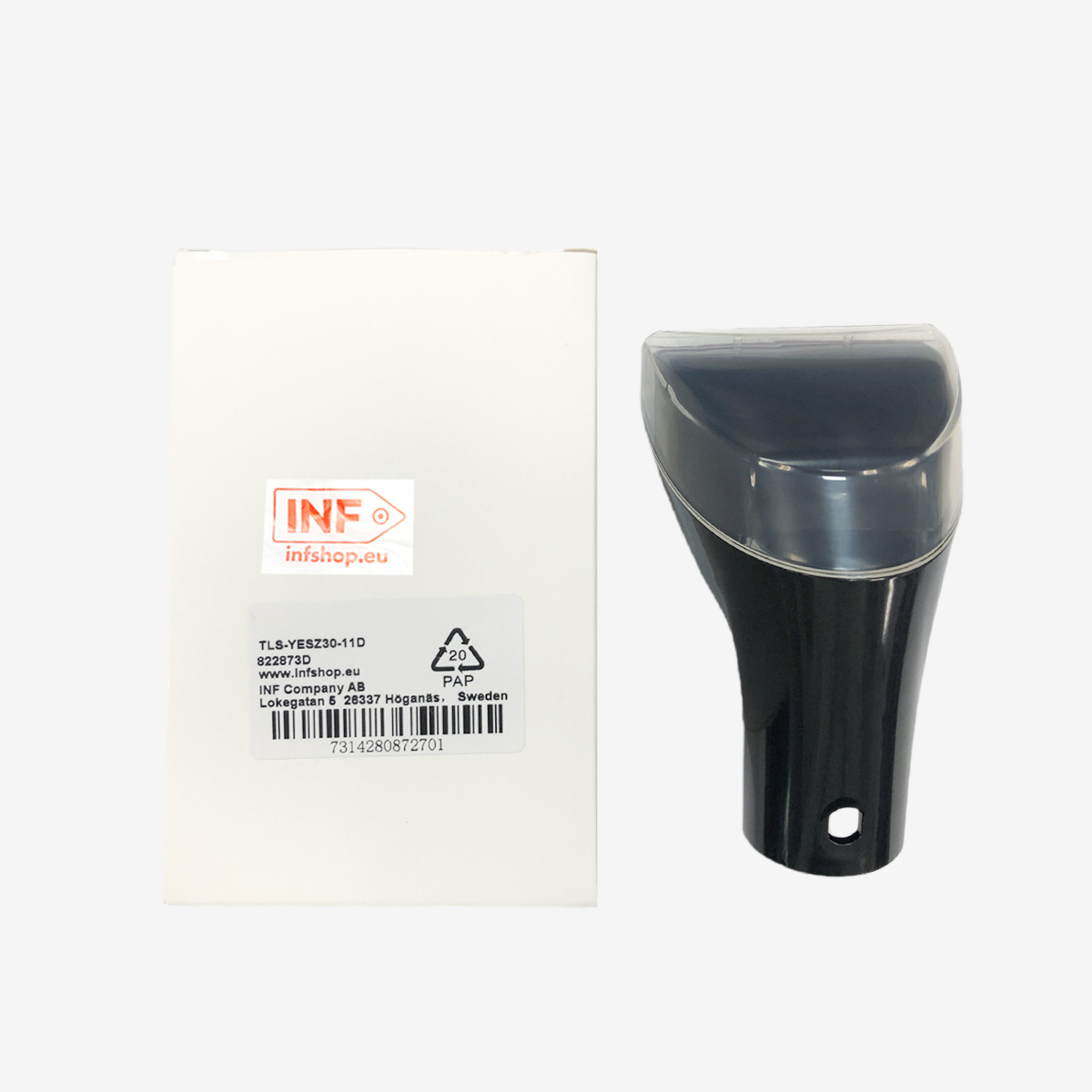 Białe pudełko z naklejką i czarny, przezroczysty plastikowy przedmiot na białym tle.