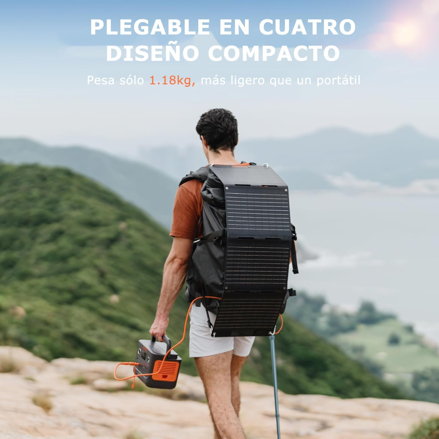Ein Mann mit Solarpanel-Rucksack geht auf einem Bergpfad. Er trägt eine tragbare Powerstation. Der Hintergrund zeigt das Meer.