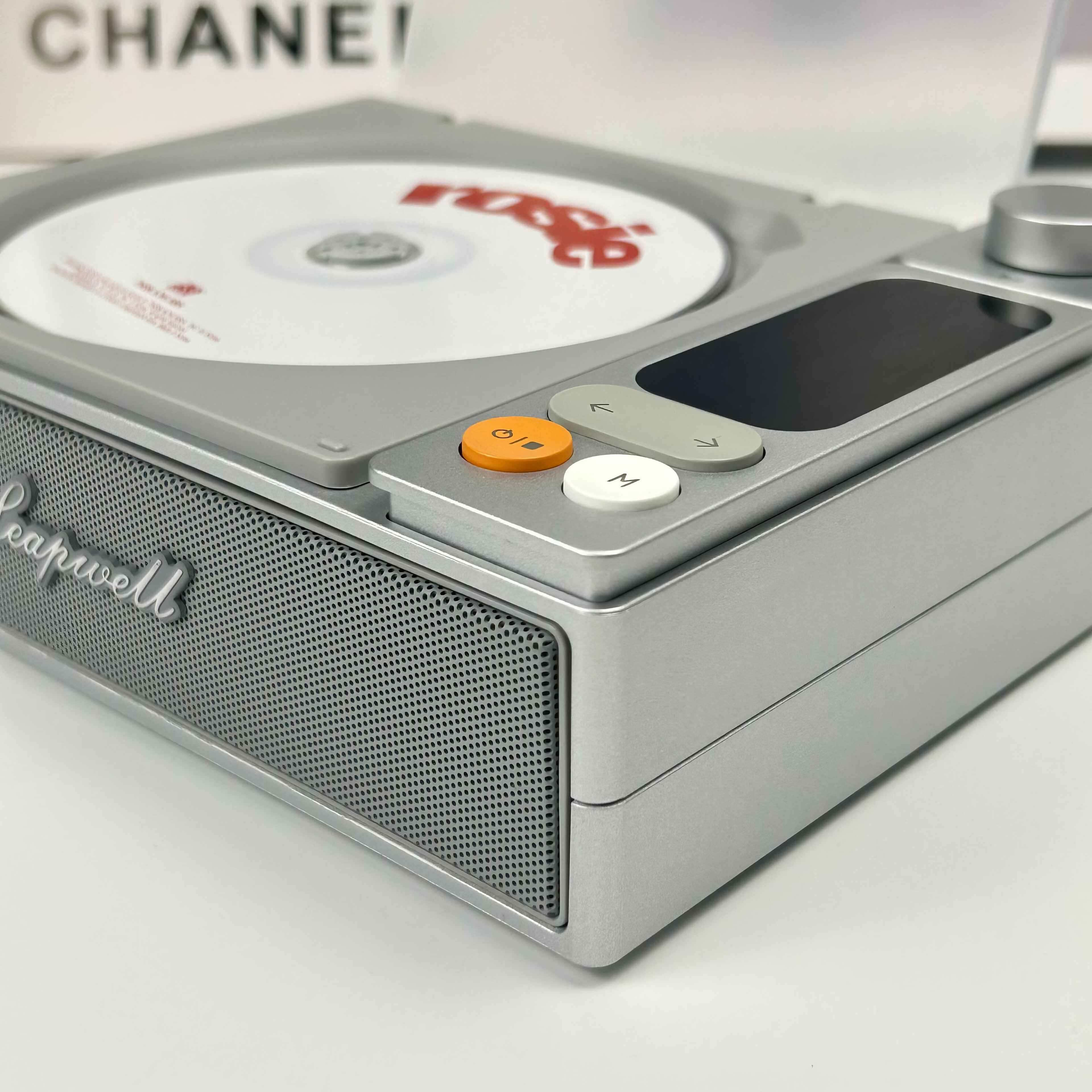 Silberner CD-Player mit CD. Orange und weiße Knöpfe vorne. "Leapwell" ist geschrieben.